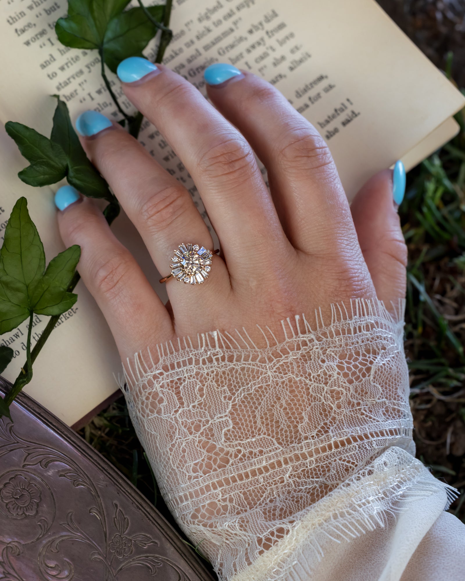 Hand wearing champagne diamond  ring with book in background