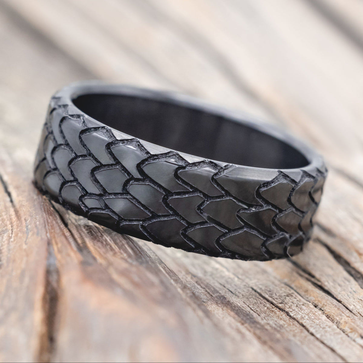 dragon scale engraved wedding band on wooden surface