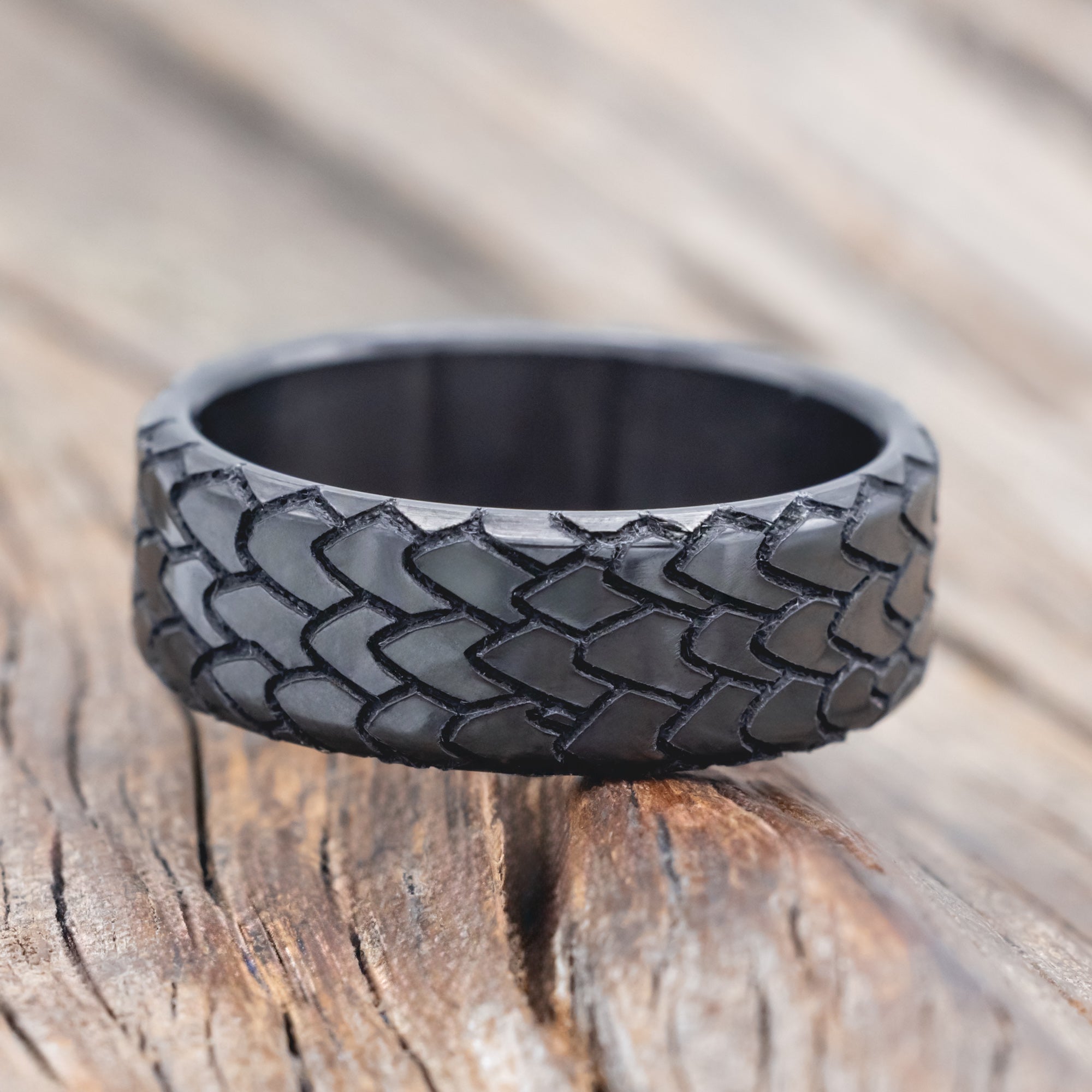 dragon scale engraved wedding band on wooden surface