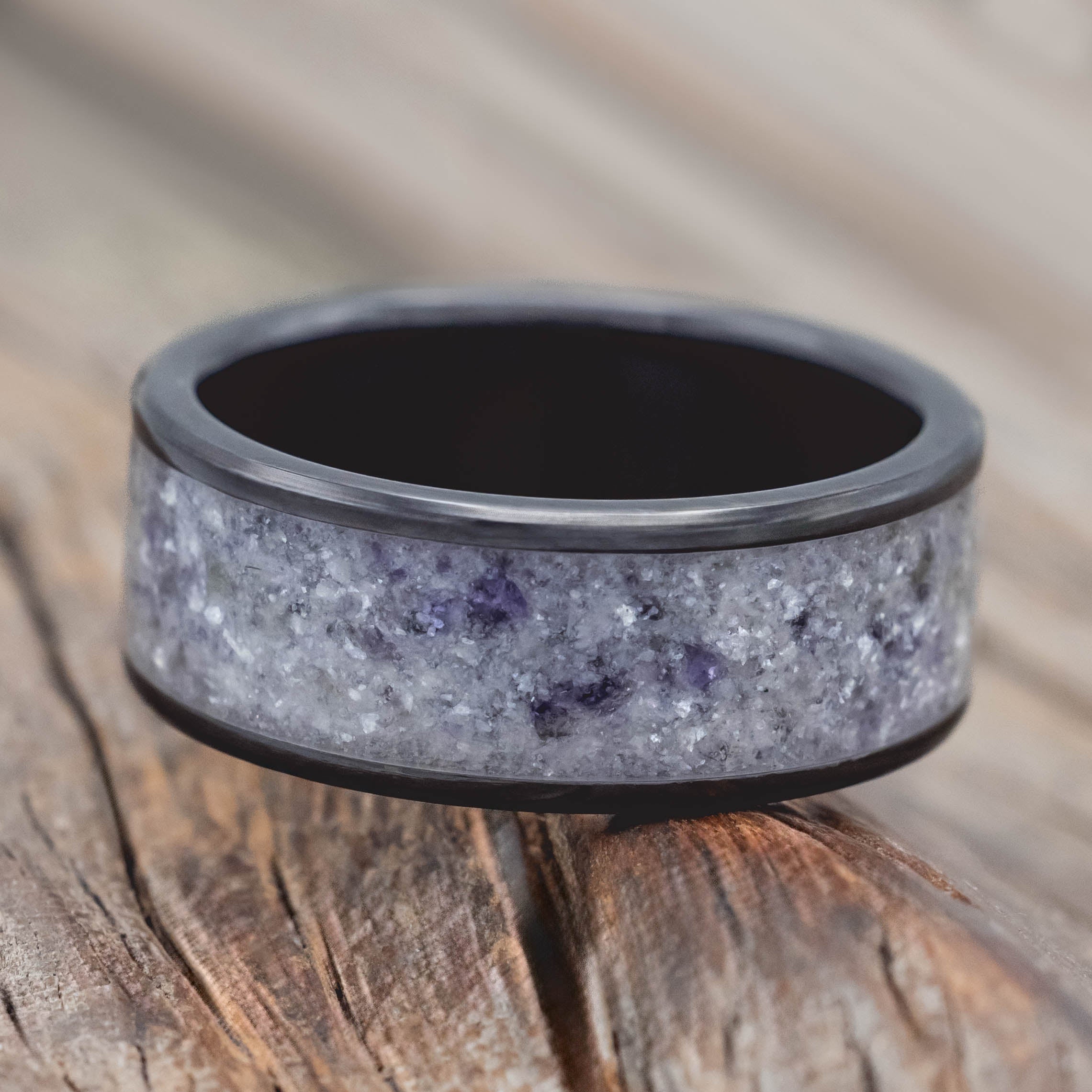 Black and gray ring with a textured design on a wooden surface
