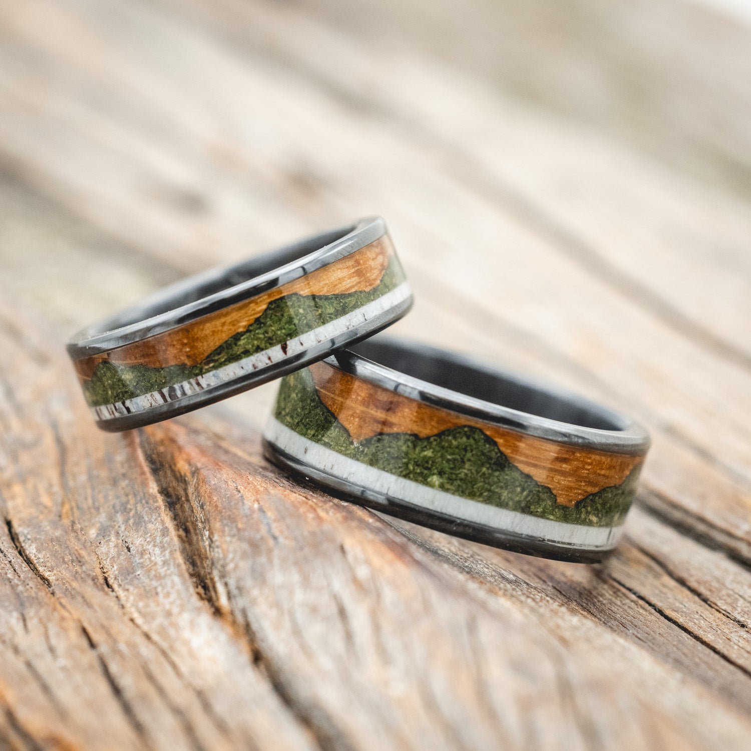 "Voyager" - matching set of wedding bands featuring moss-filled mountain engraving with whiskey barrel oak & antler inlays