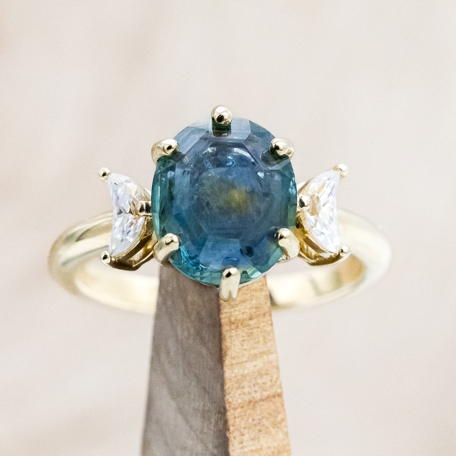 "Rhiannon" engagement ring with a portrait cut Montana sapphire and two crescent moon moissanite accents