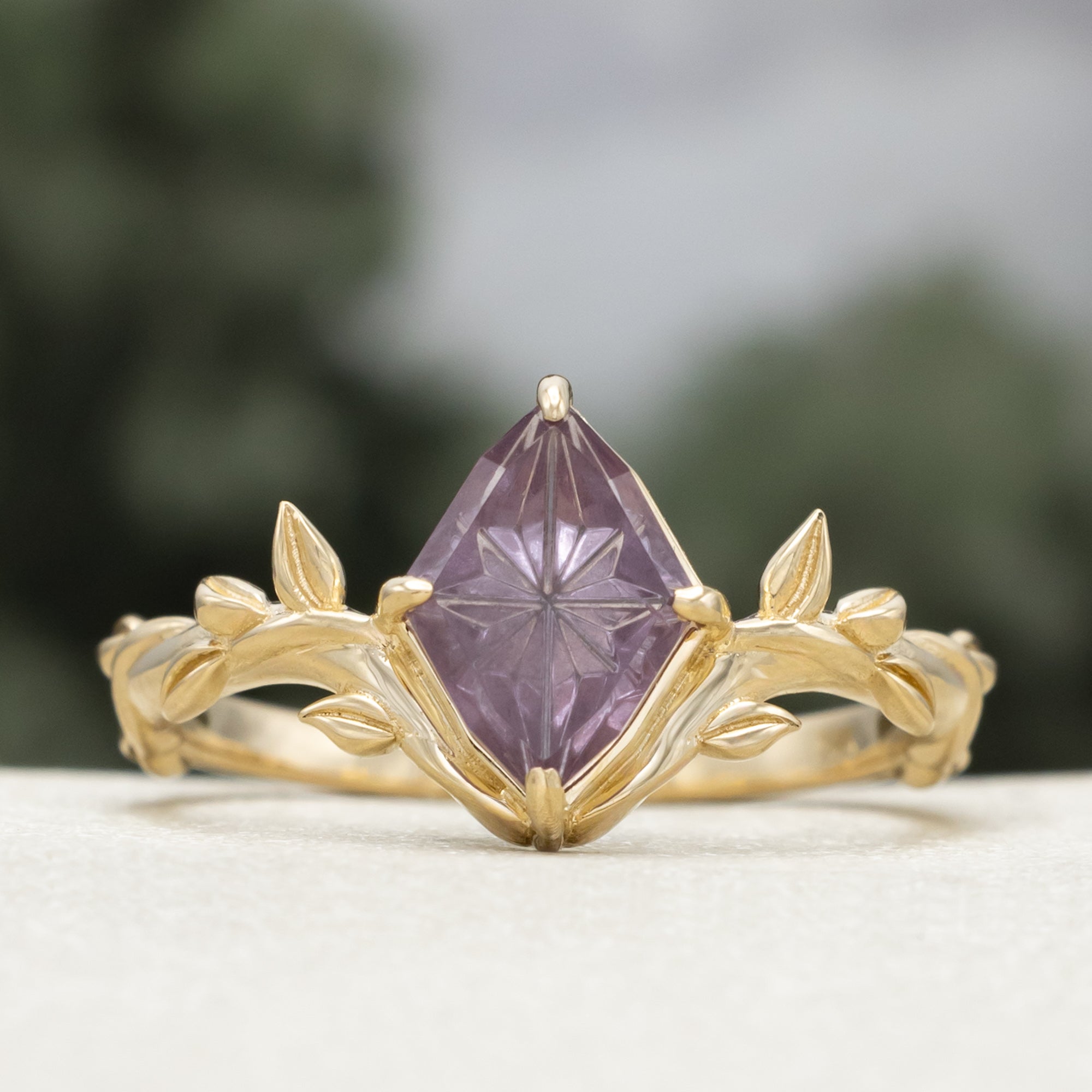 Gold ring with a dragon garnet on a blurred background