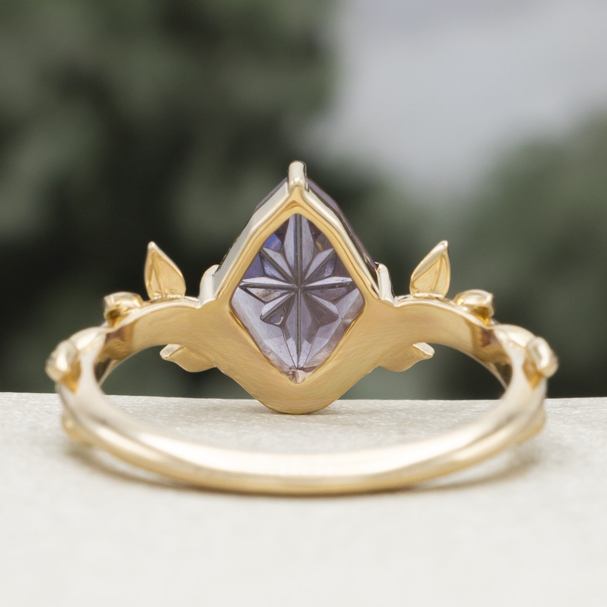Gold ring with a dragon garnet on a blurred background