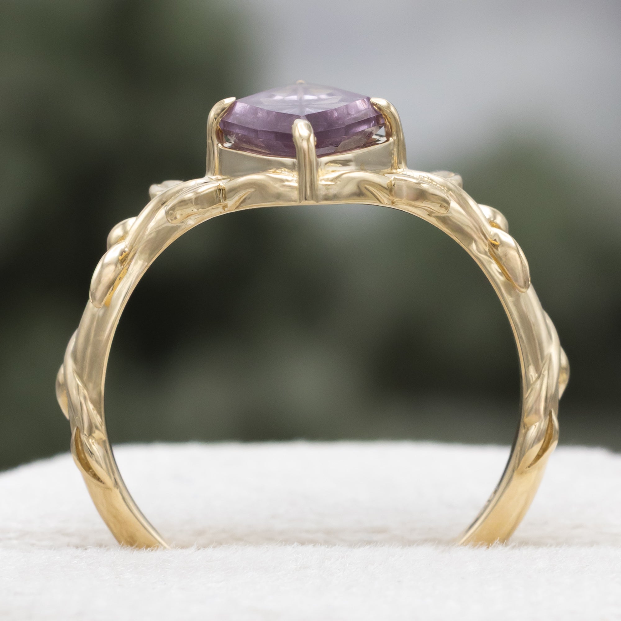 Gold ring with a dragon garnet on a blurred background