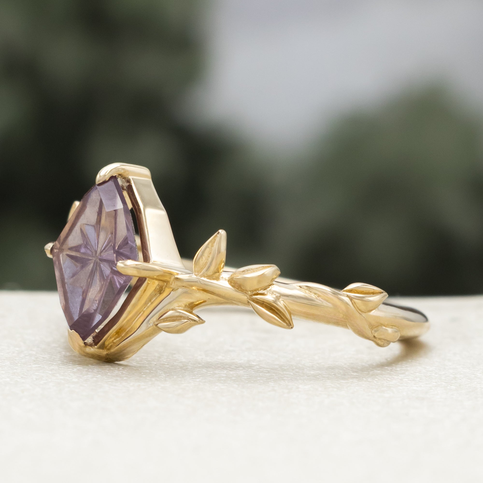 Gold ring with a dragon garnet on a blurred background