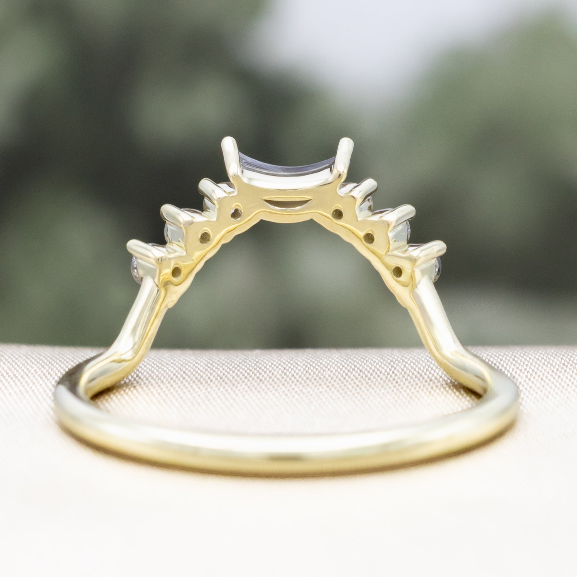 Green gold ring with salt & pepper diamond accents on a neutral background