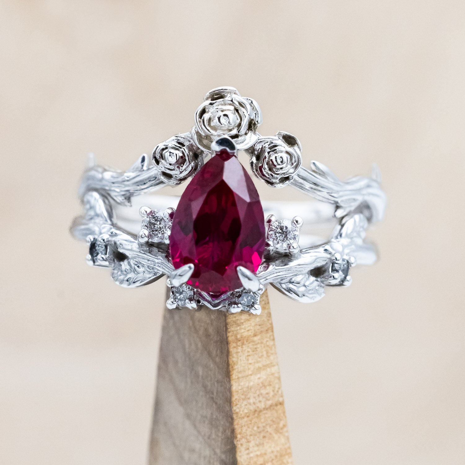 "Harlow" pear cut ruby engagement ring with salt & pepper diamond accents on a branch-inspired band and floral style tracer
