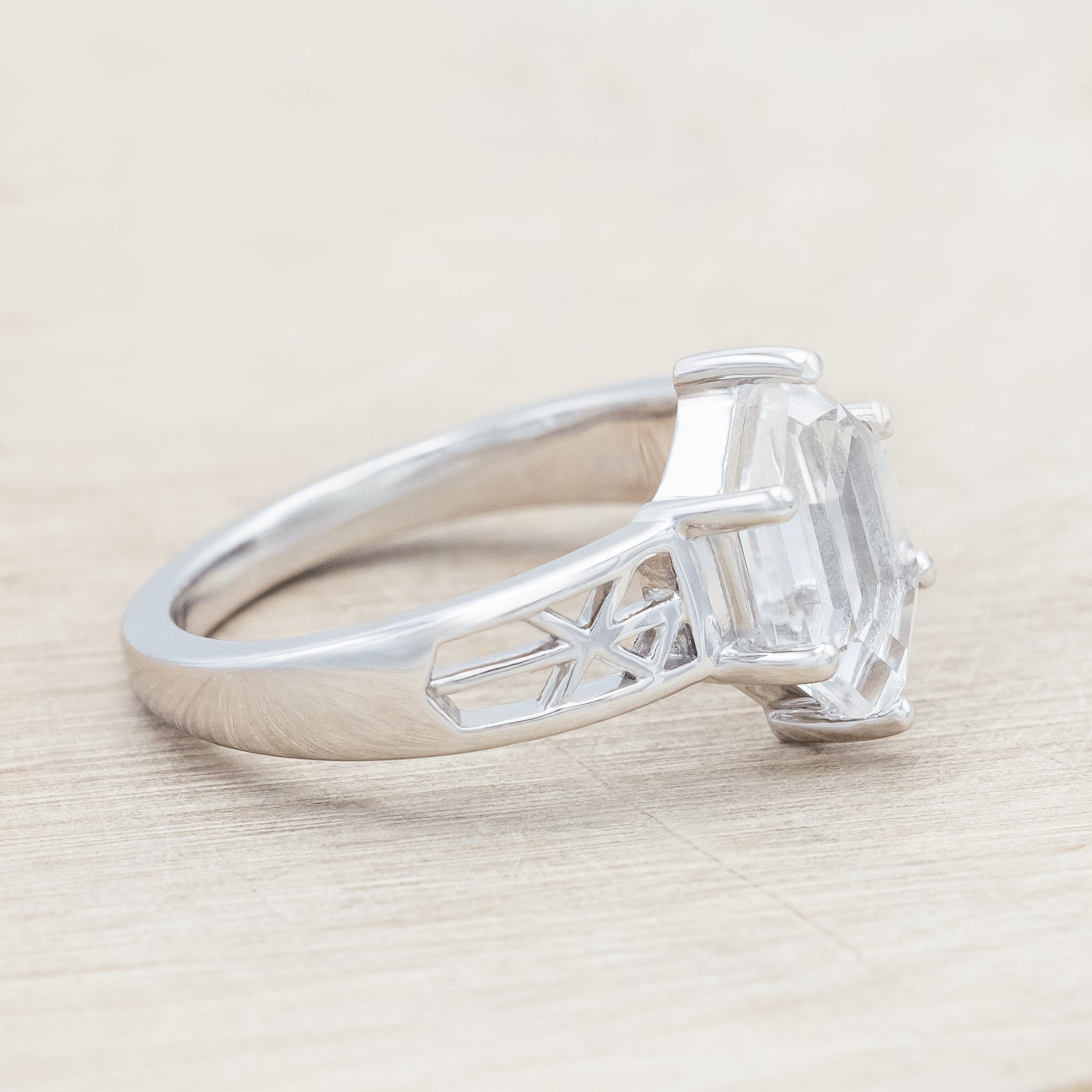 White gold ring with Nordic rune design with white quartz on a beige background