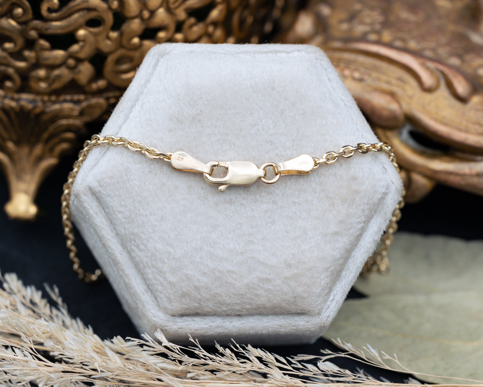 clap of chain necklace on a hexagonal gray velvet stand.