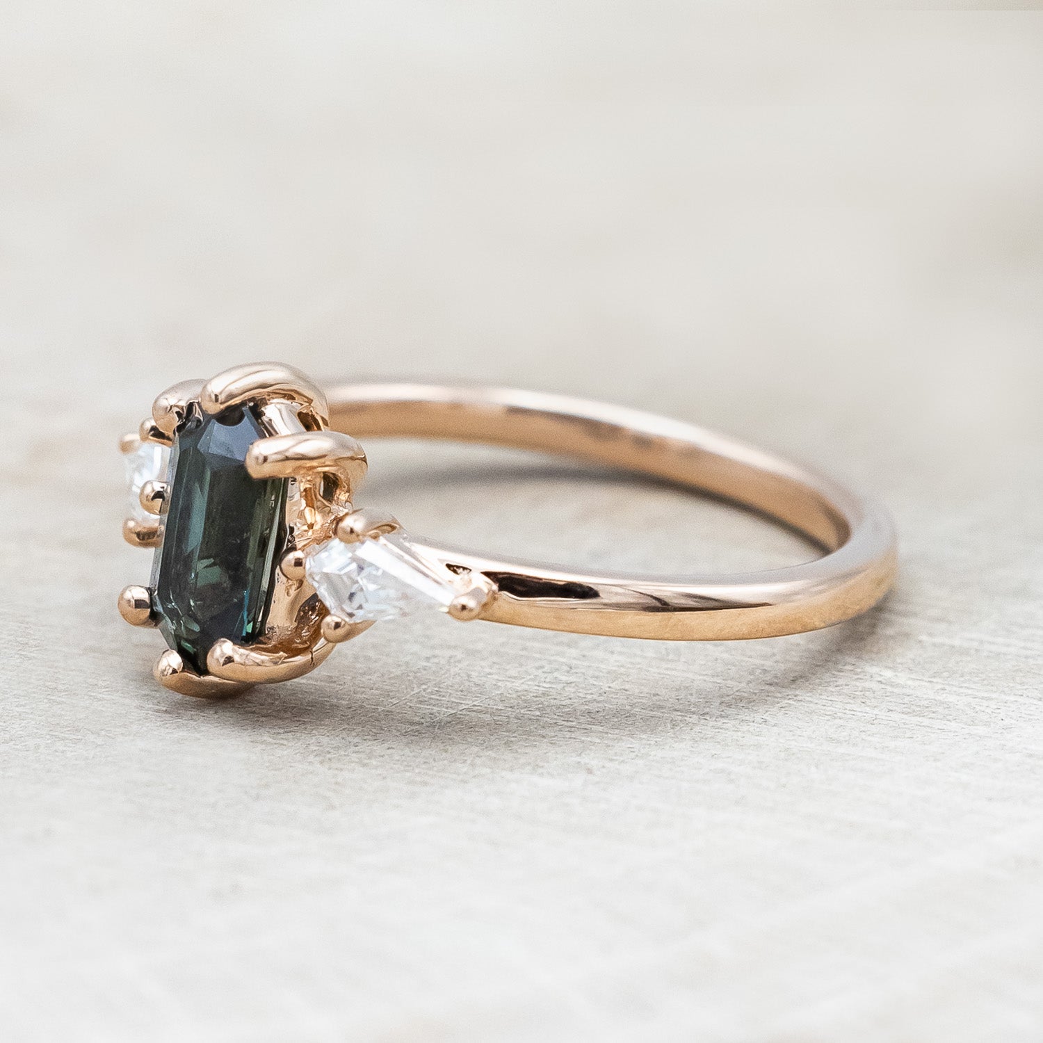 Side view of "Isla" - elongated hexagon cut Australian sapphire with moissanite accents in 14K rose gold
