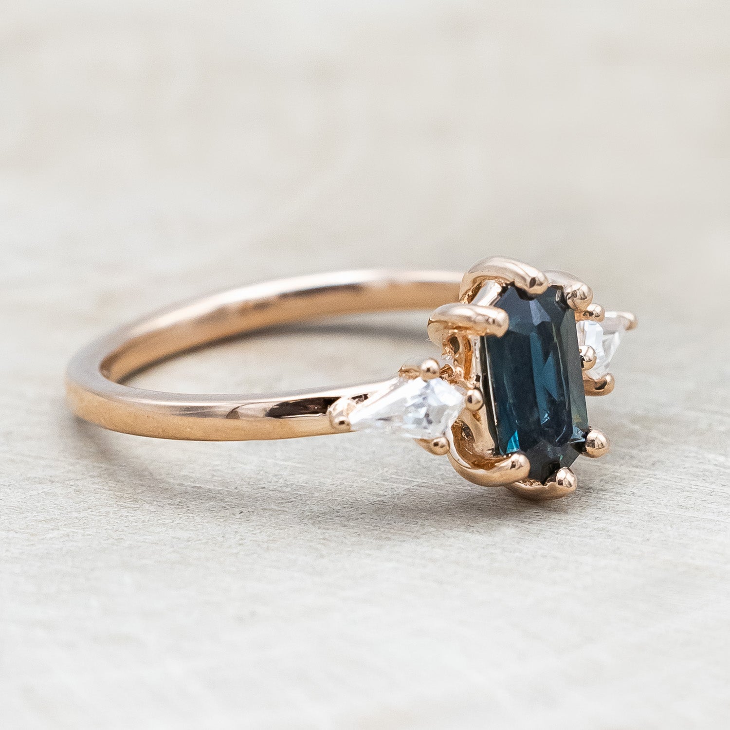 Side view of "Isla" - elongated hexagon cut Australian sapphire with moissanite accents in 14K rose gold