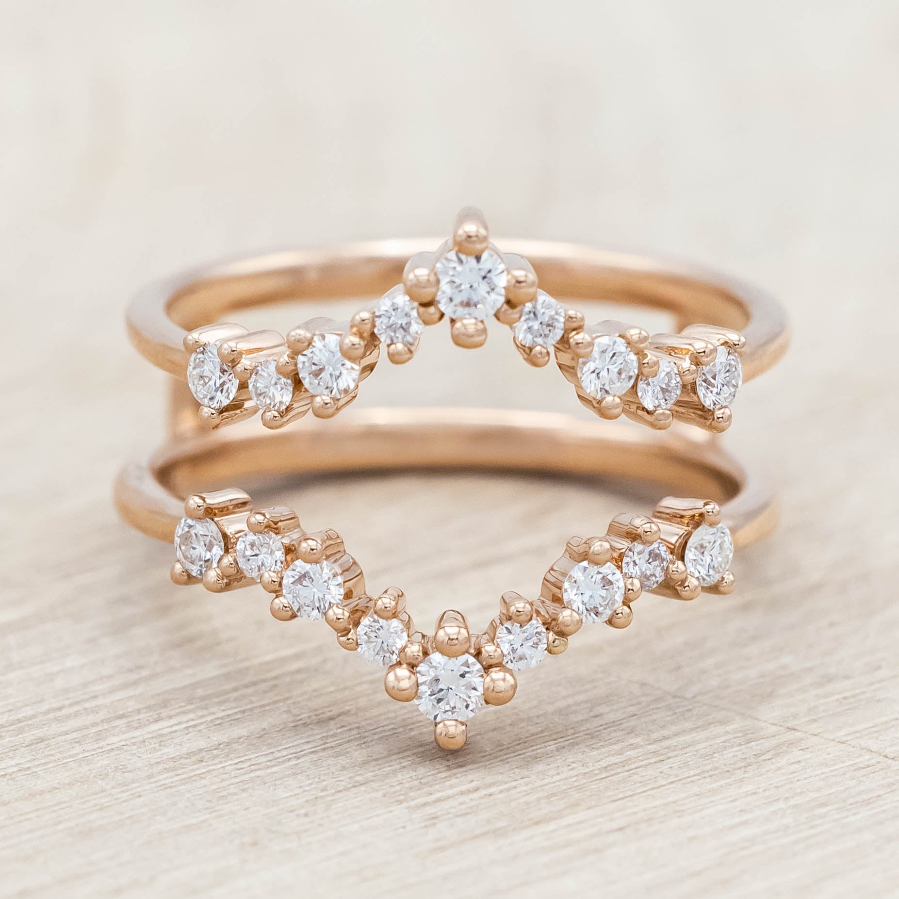 14K rose gold ring with diamond accents on a light wooden surface