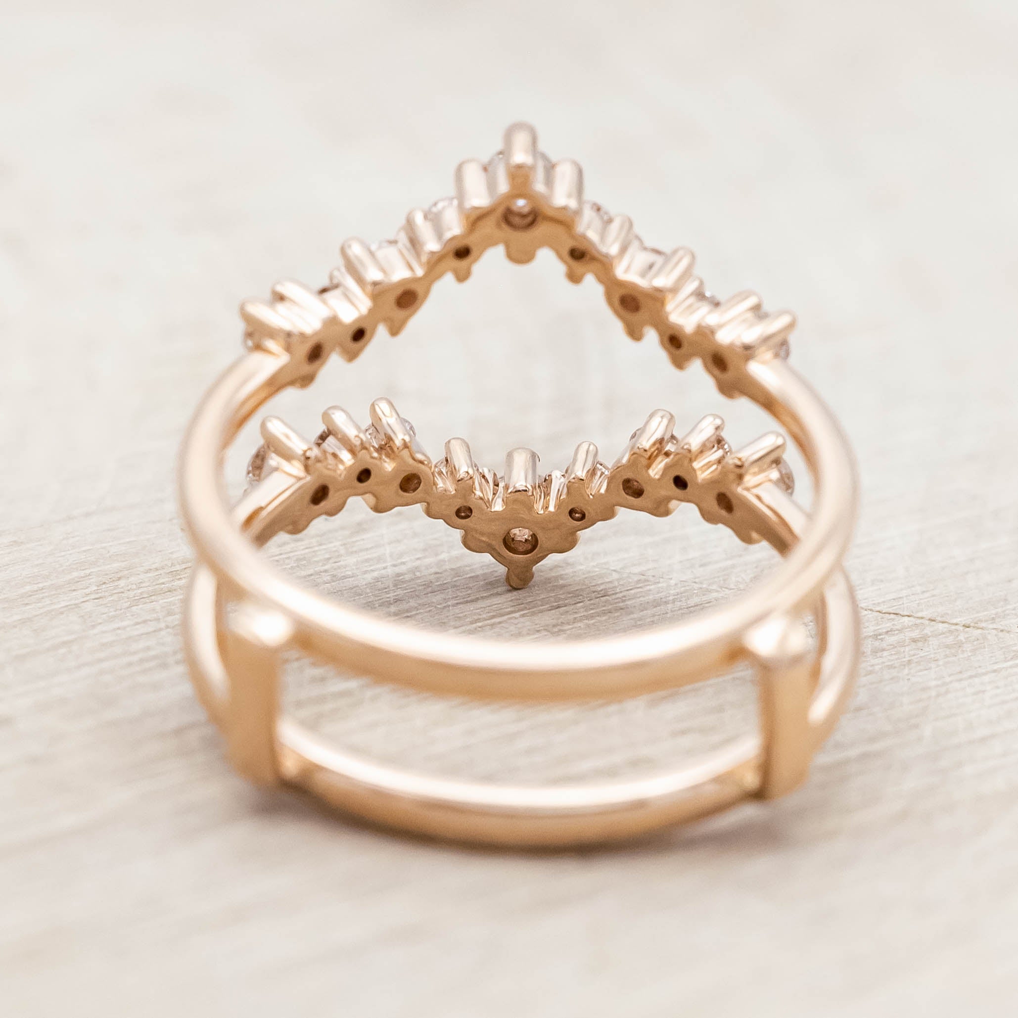 14K rose gold ring with diamond accents on a light wooden surface