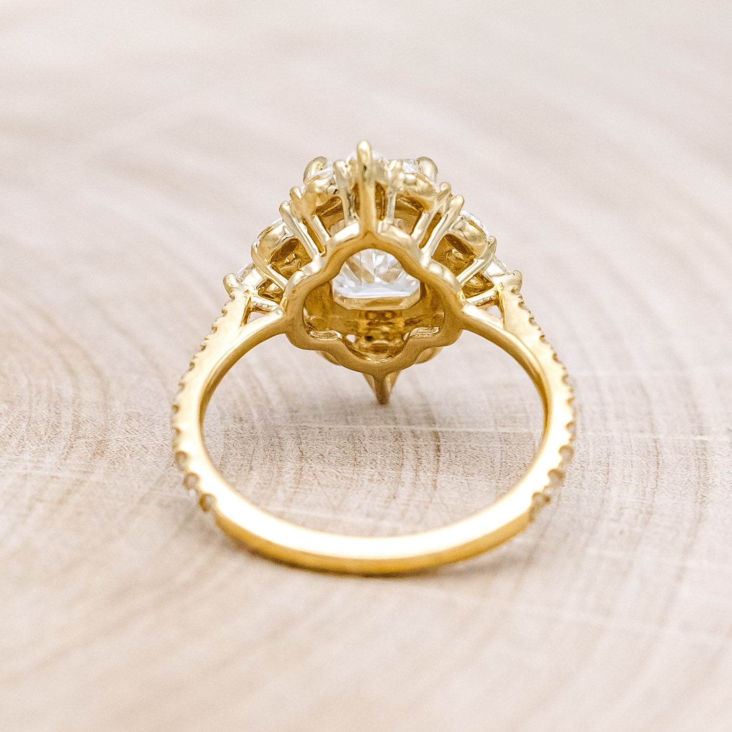 Back view of "North Star" - emerald cut diamond women's engagement ring with a diamond halo and accents on a 14K yellow gold band