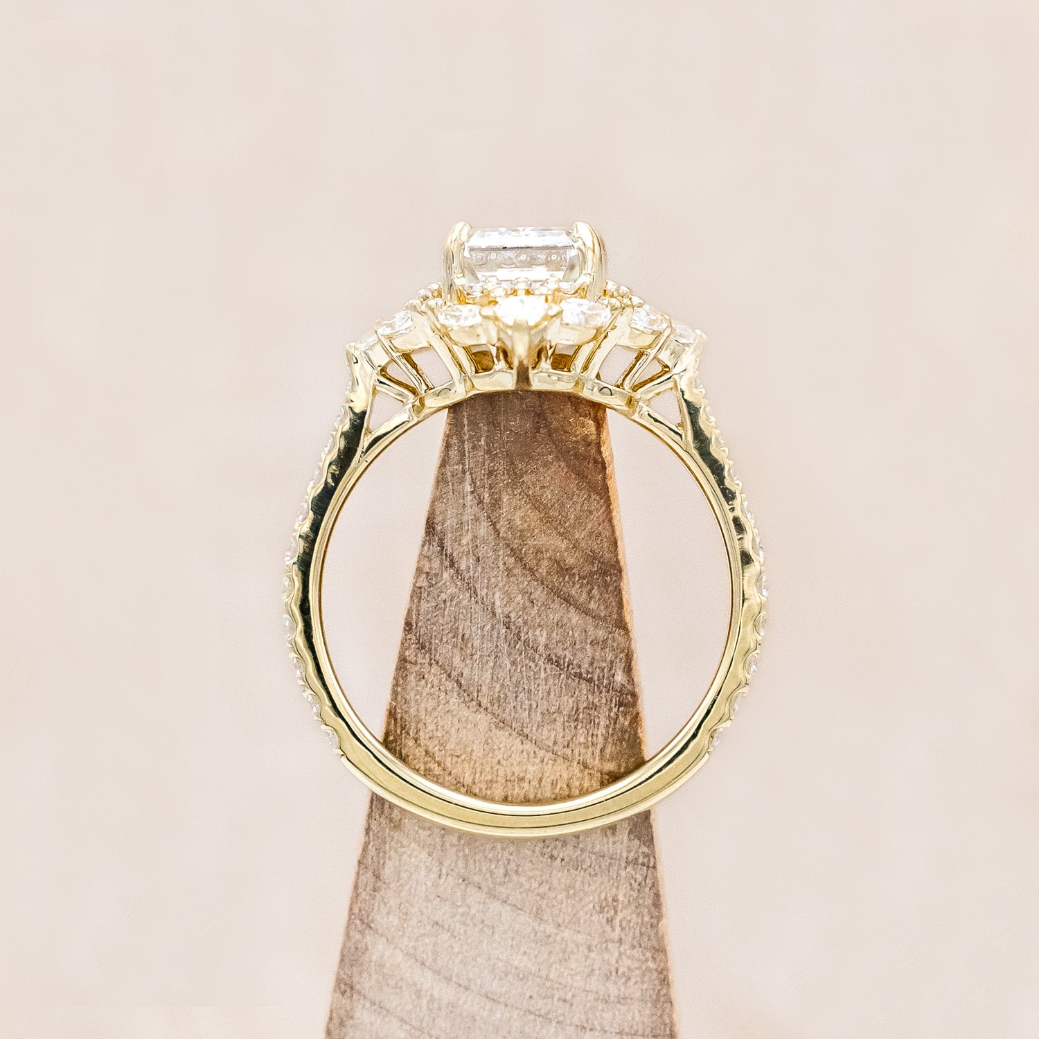 Top view of "North Star" - emerald cut diamond women's engagement ring with a diamond halo and accents on a 14K yellow gold band