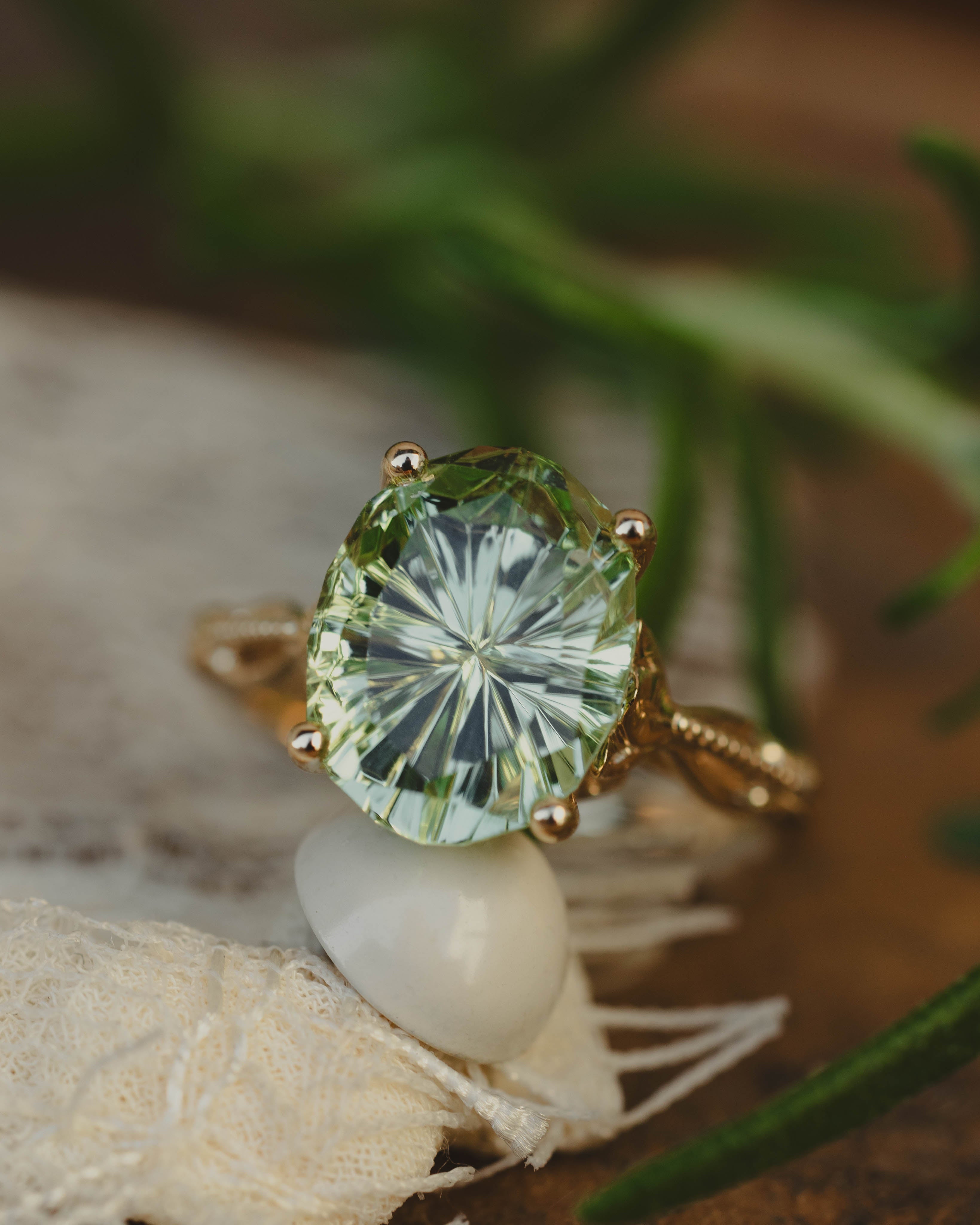 Gold ring with a green gemstone on a natural background