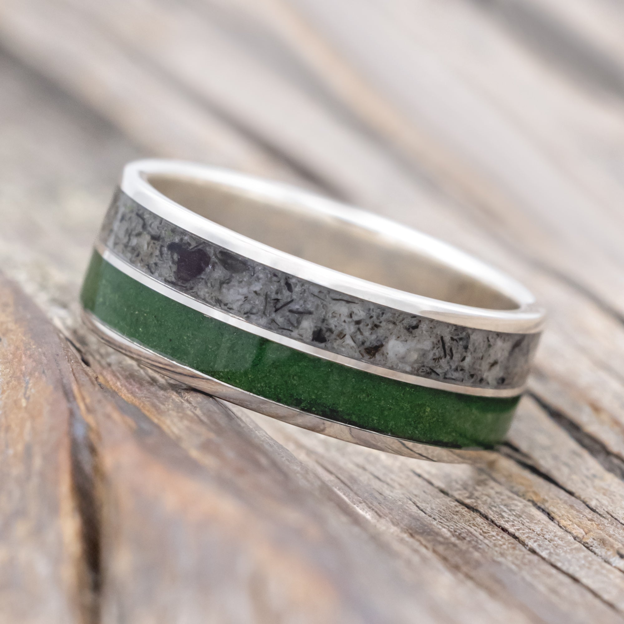 Silver ring with moss and moonstone inlay on a wooden surface