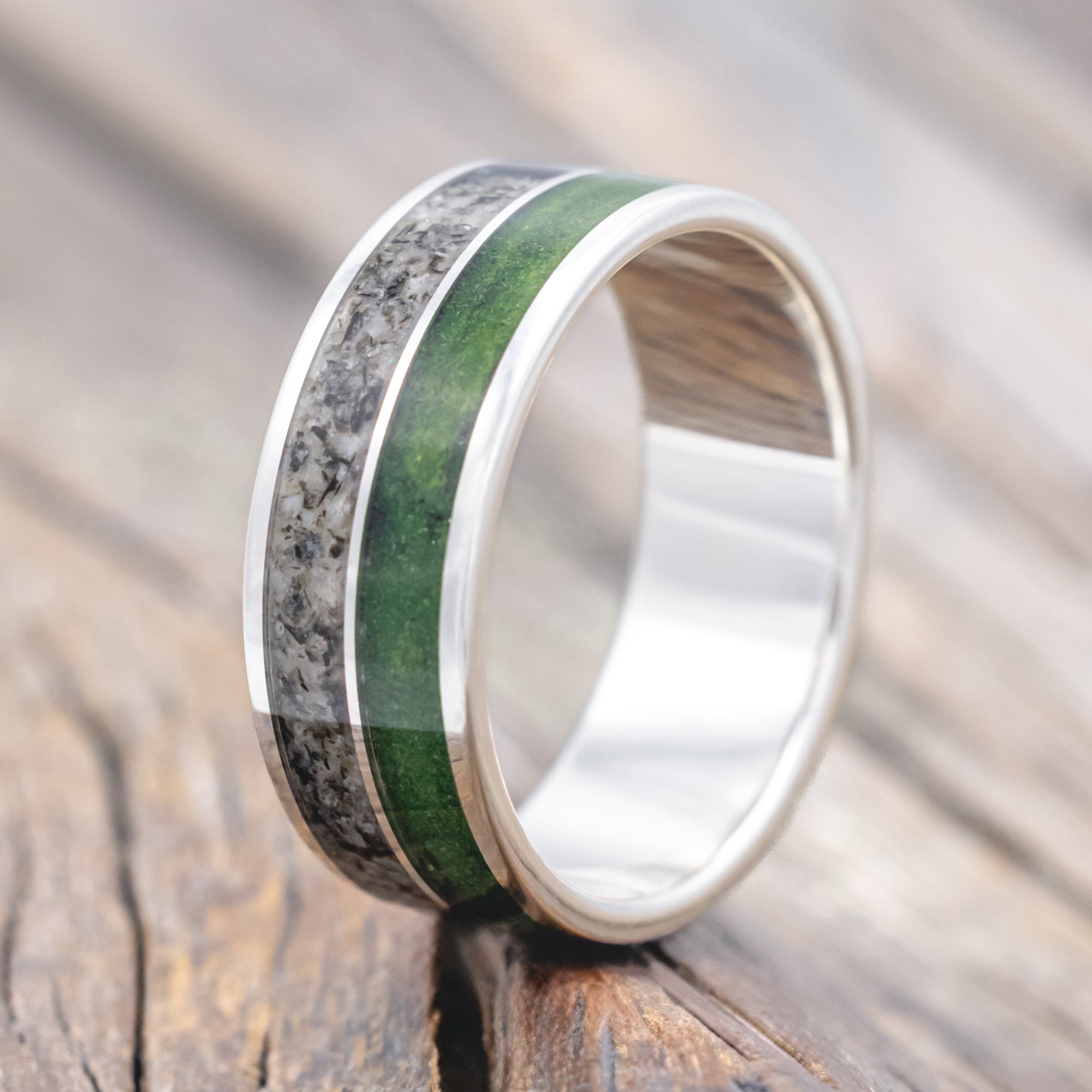 Silver ring with moss and moonstone inlay on a wooden surface