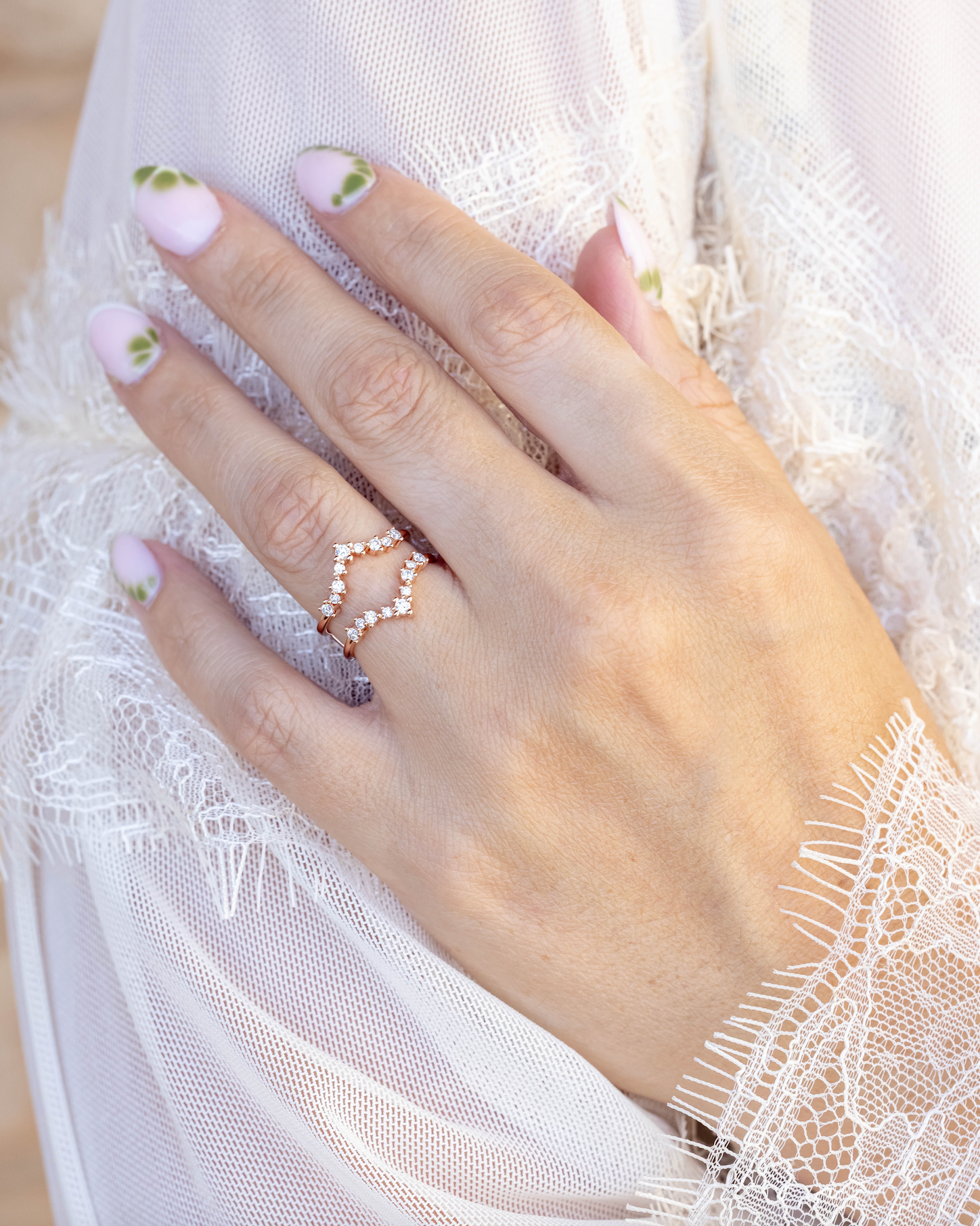 Hand wearing a diamond accented ring guard against a white dress