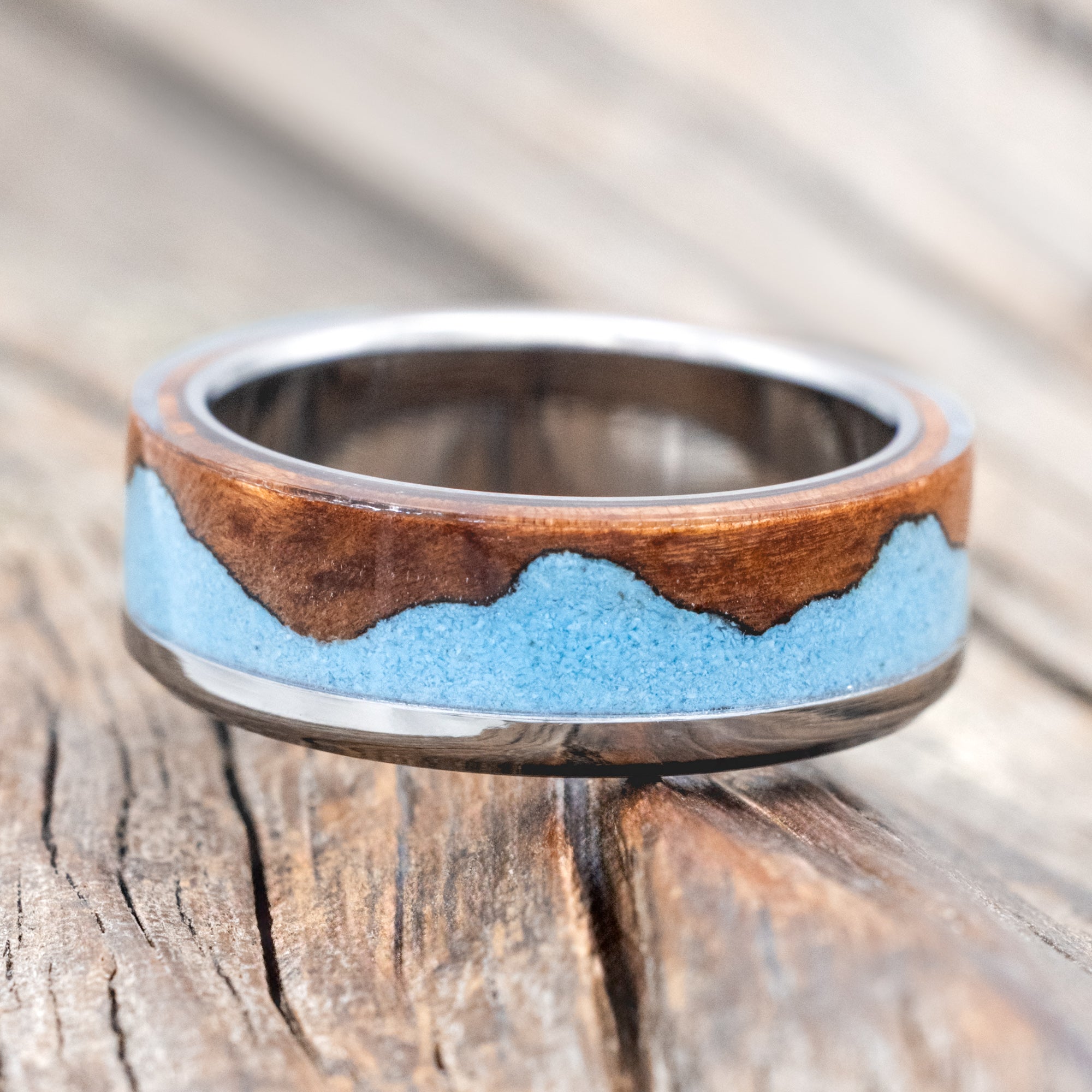 ring with redwood and turquoise inlay on a wooden surface