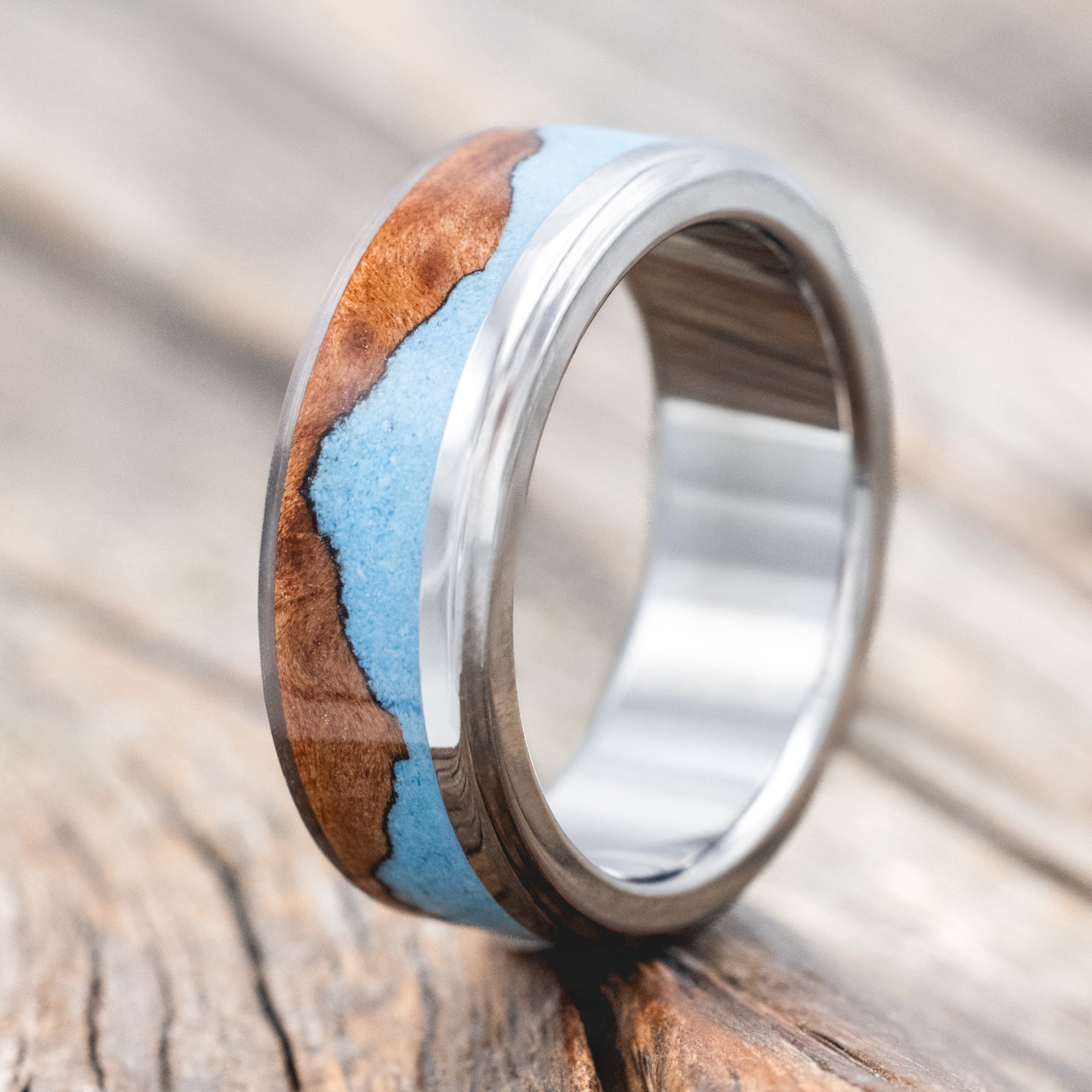 ring with redwood and turquoise inlay on a wooden surface