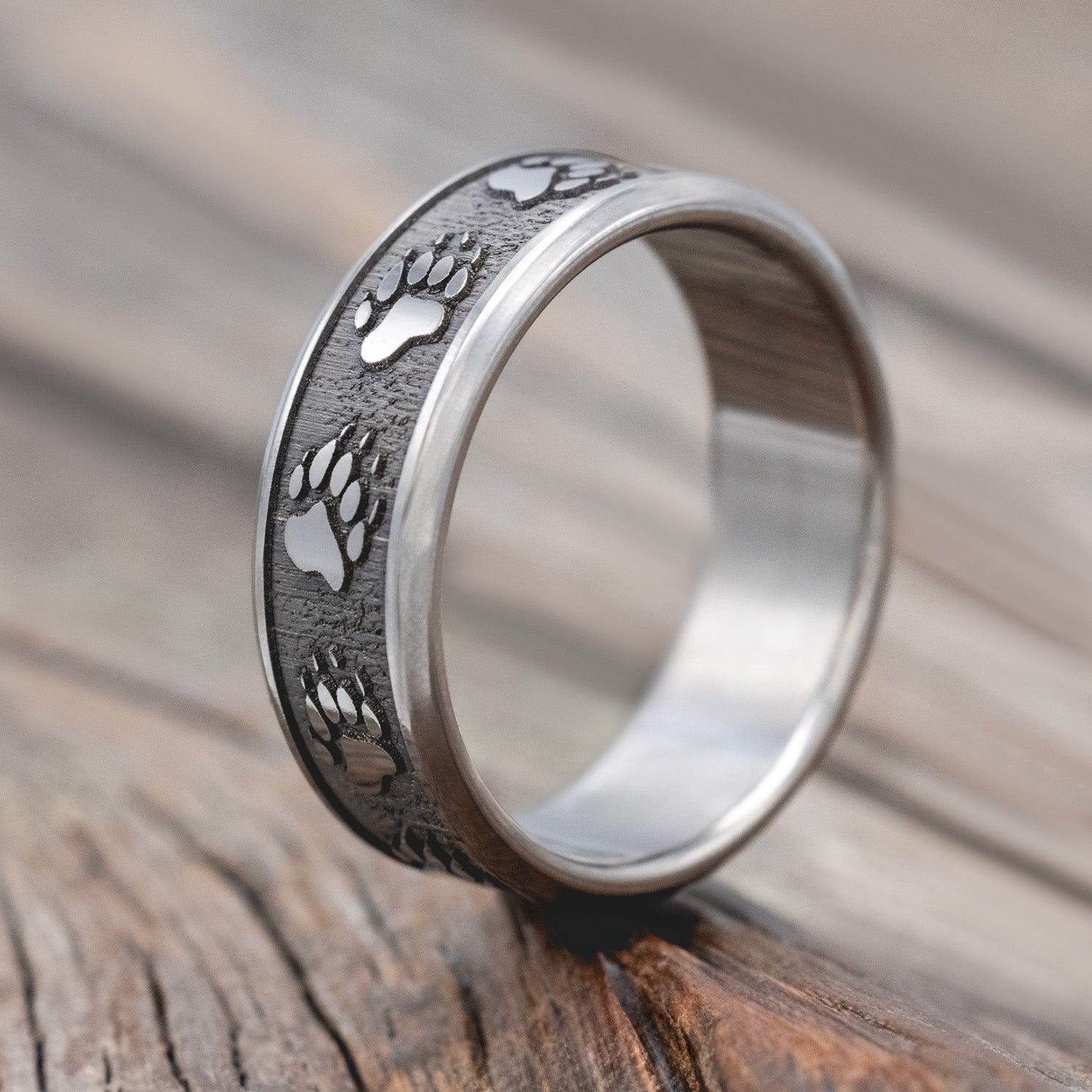 "Legacy" - embossed wedding rings with bear paw engravings on channel-style band. 