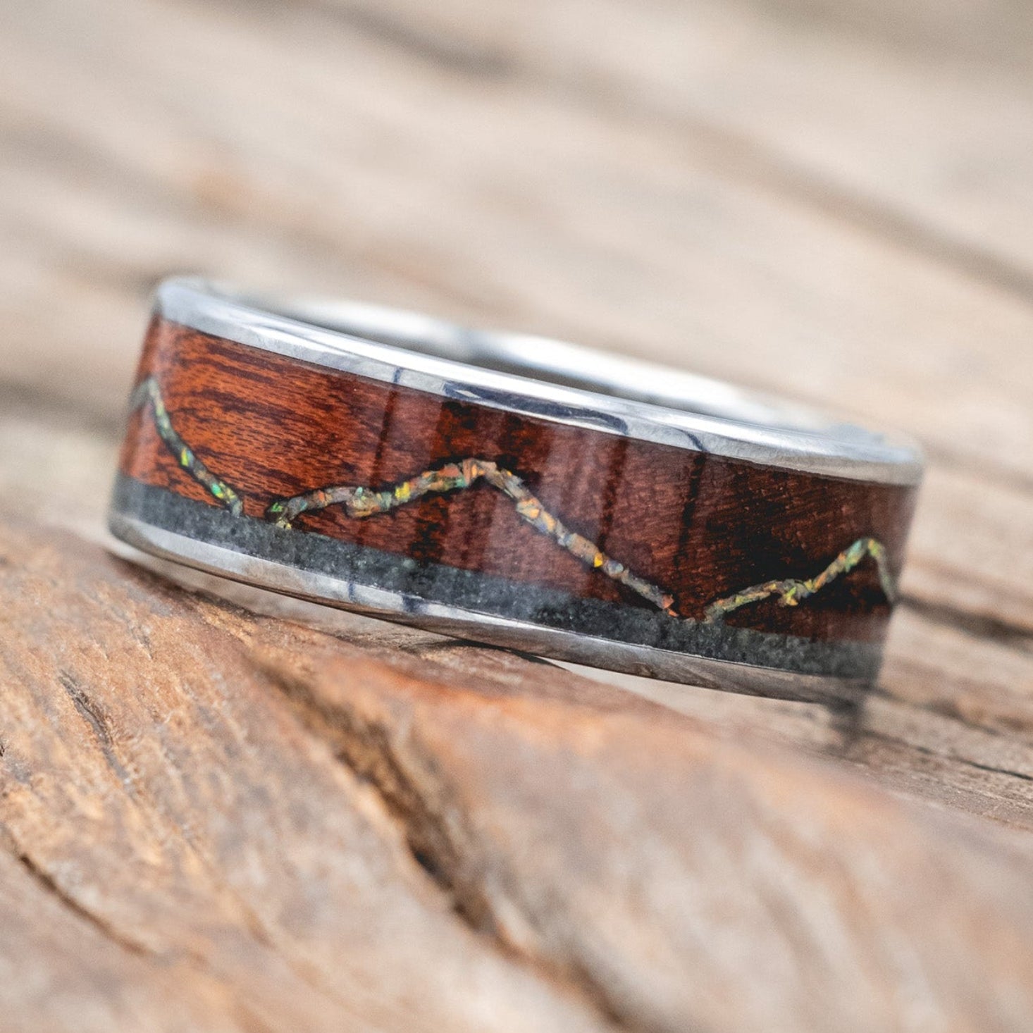 "The Expedition" - men's wedding ring featuring a mountain engraving with fire & ice opal, rosewood, and moss agate inlays