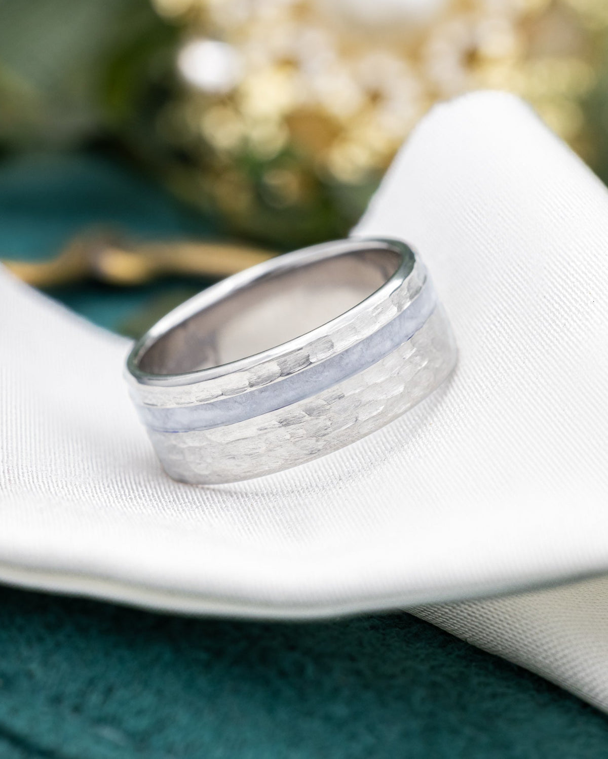 titanium ring with a hammered band on a piece of wedding dress on a piece of white fabric