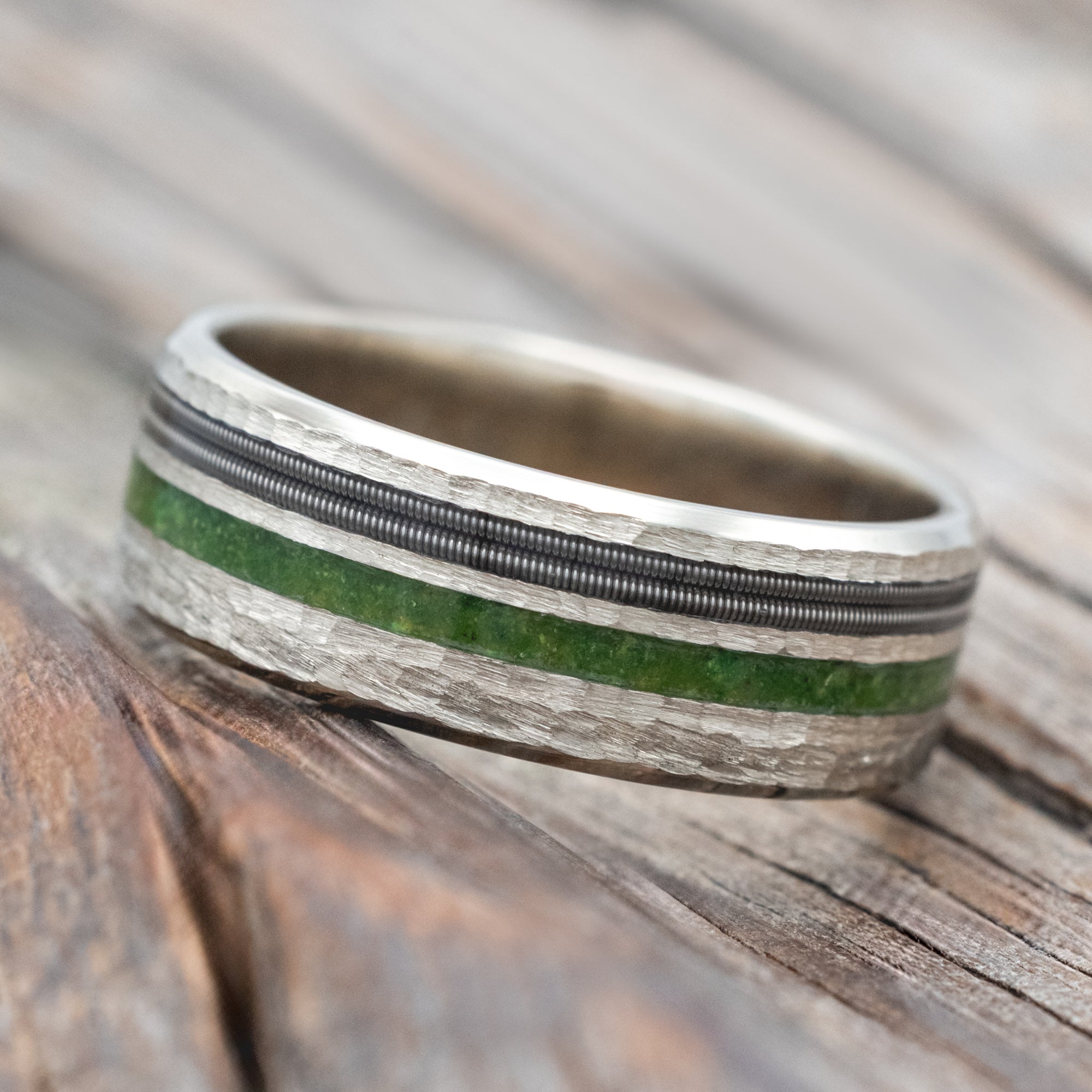 14K white gold ring with moss and guitar inlay on a wooden surface