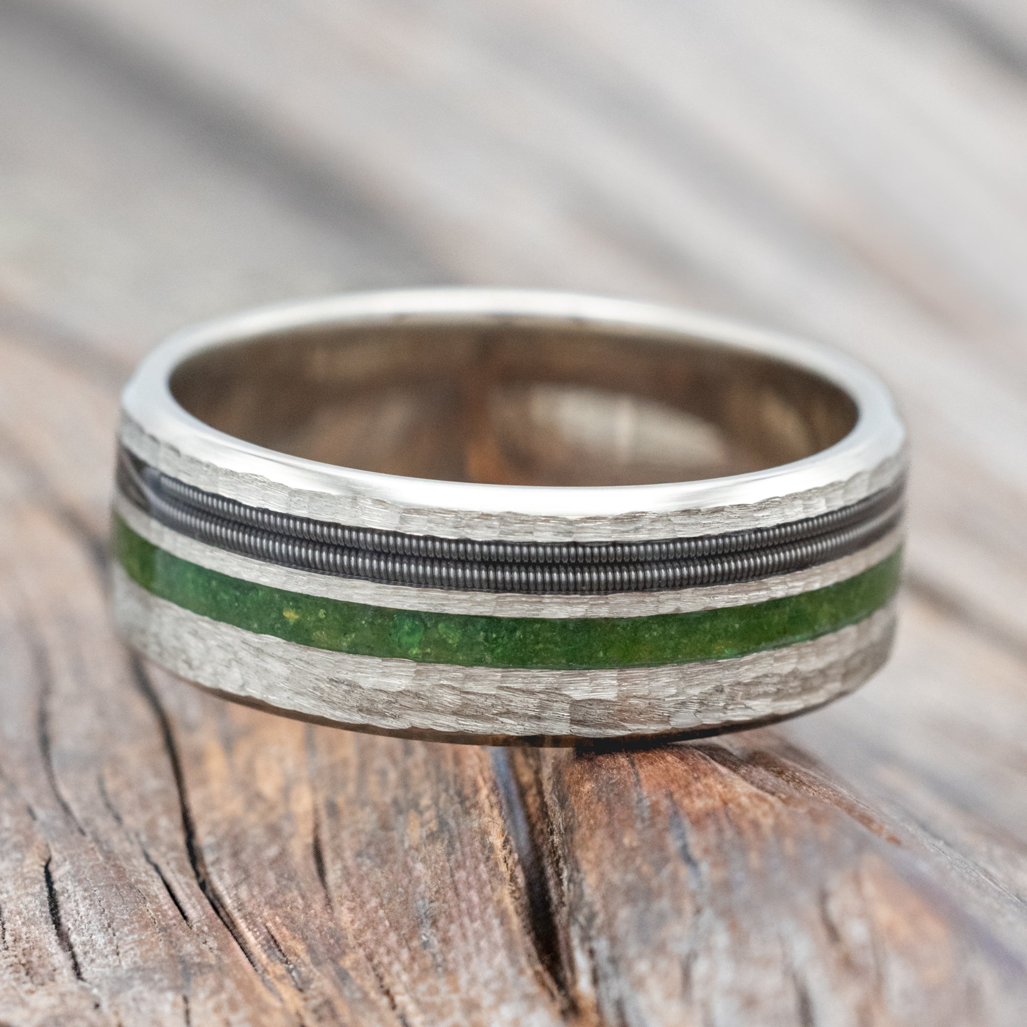 14K white gold ring with moss and guitar inlay on a wooden surface