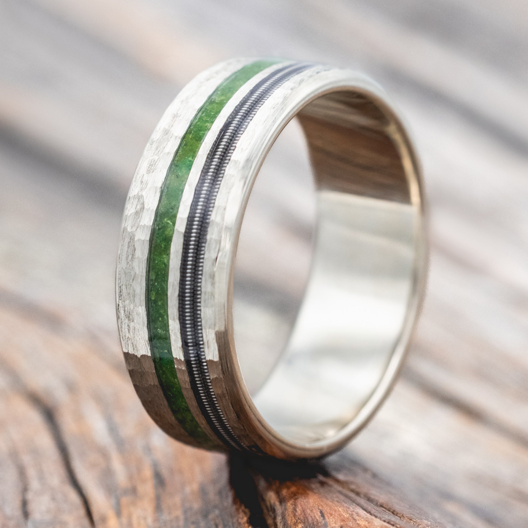 14K white gold ring with moss and guitar inlay on a wooden surface