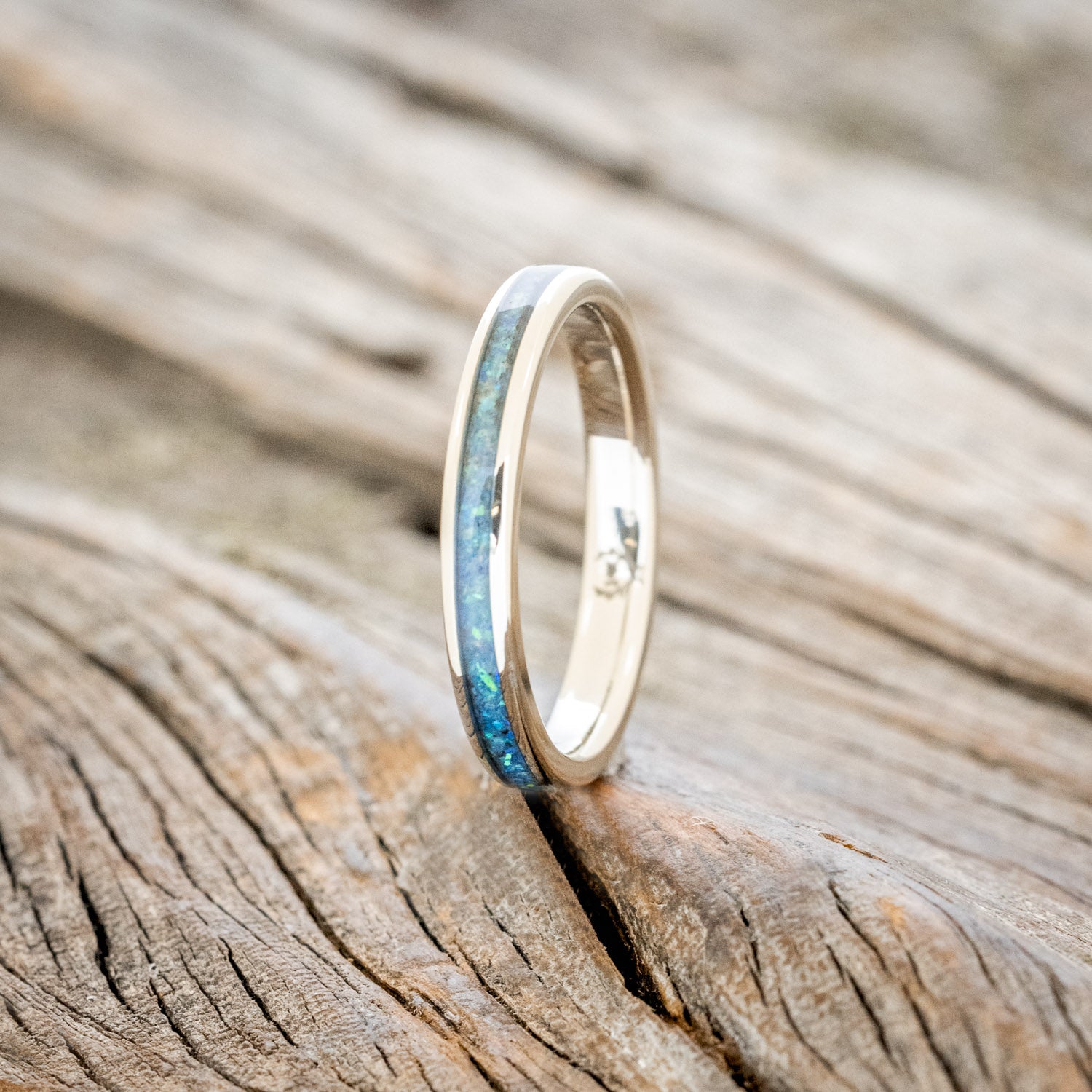 14K white gold ring with blue opal inlay on a wooden surface