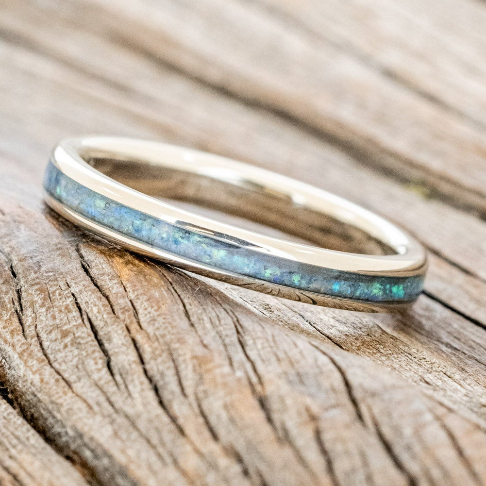14K white gold ring with blue opal inlay on a wooden surface