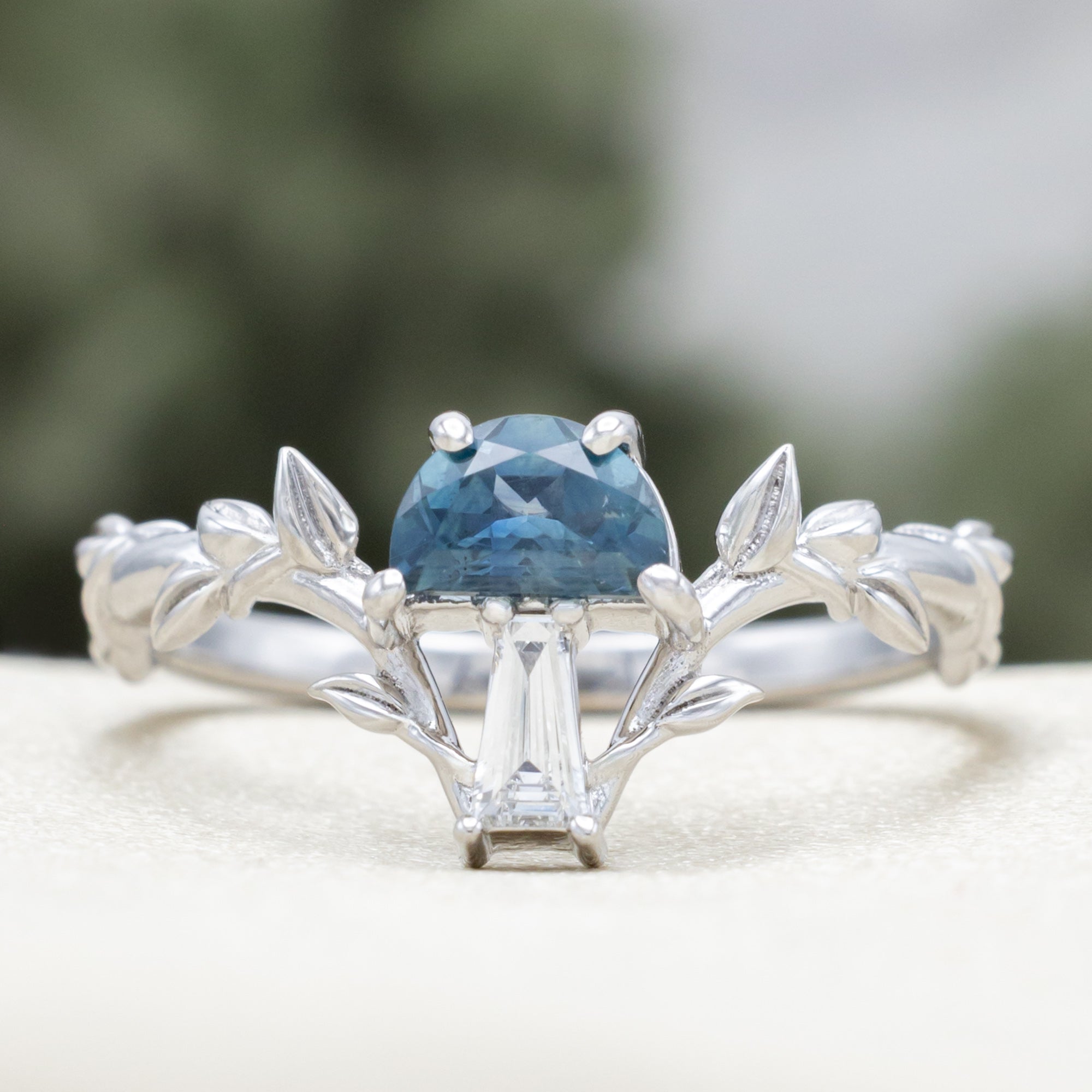 White gold mushroom ring with a blue sapphire on  a white surface