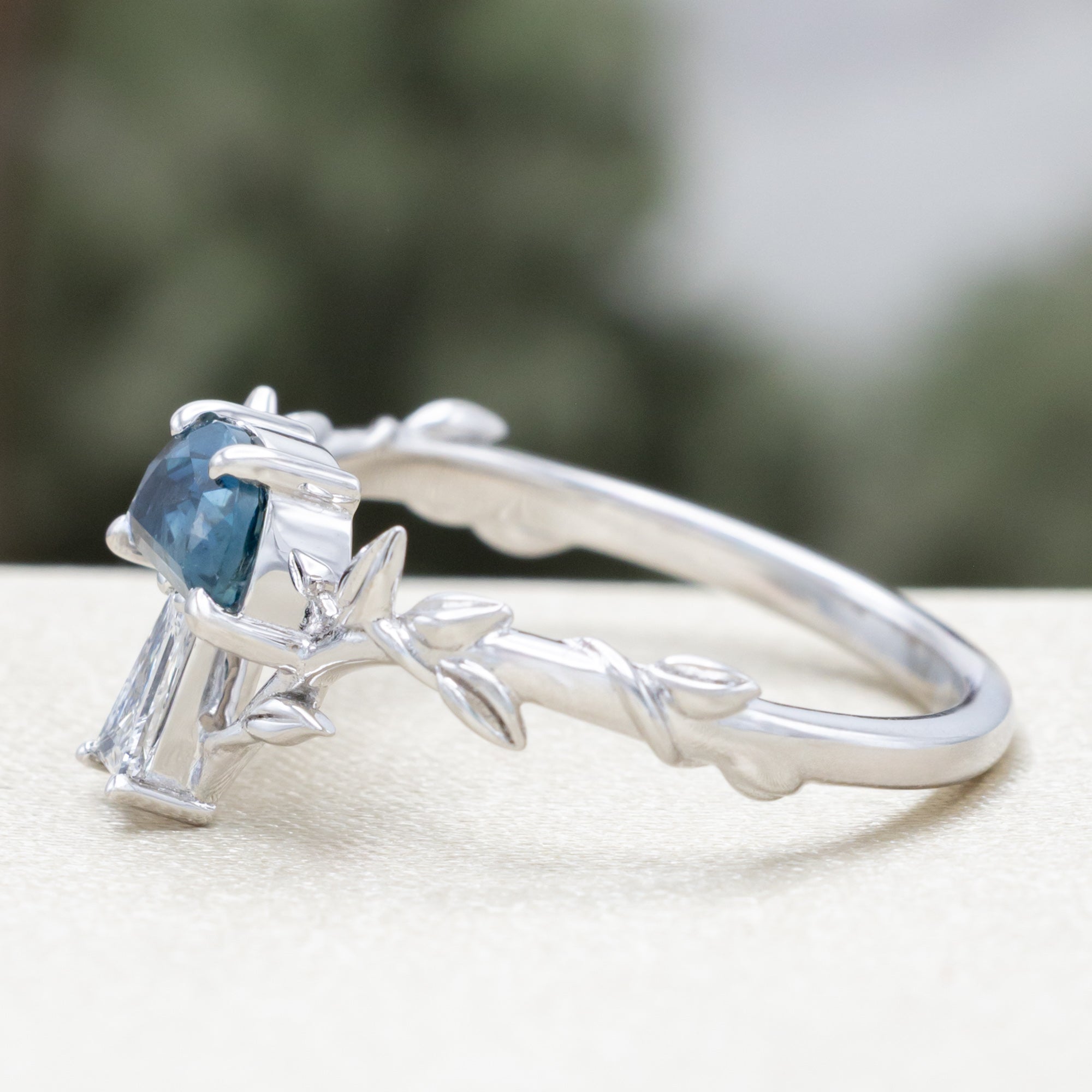 White gold mushroom ring with a blue sapphire on  a white surface