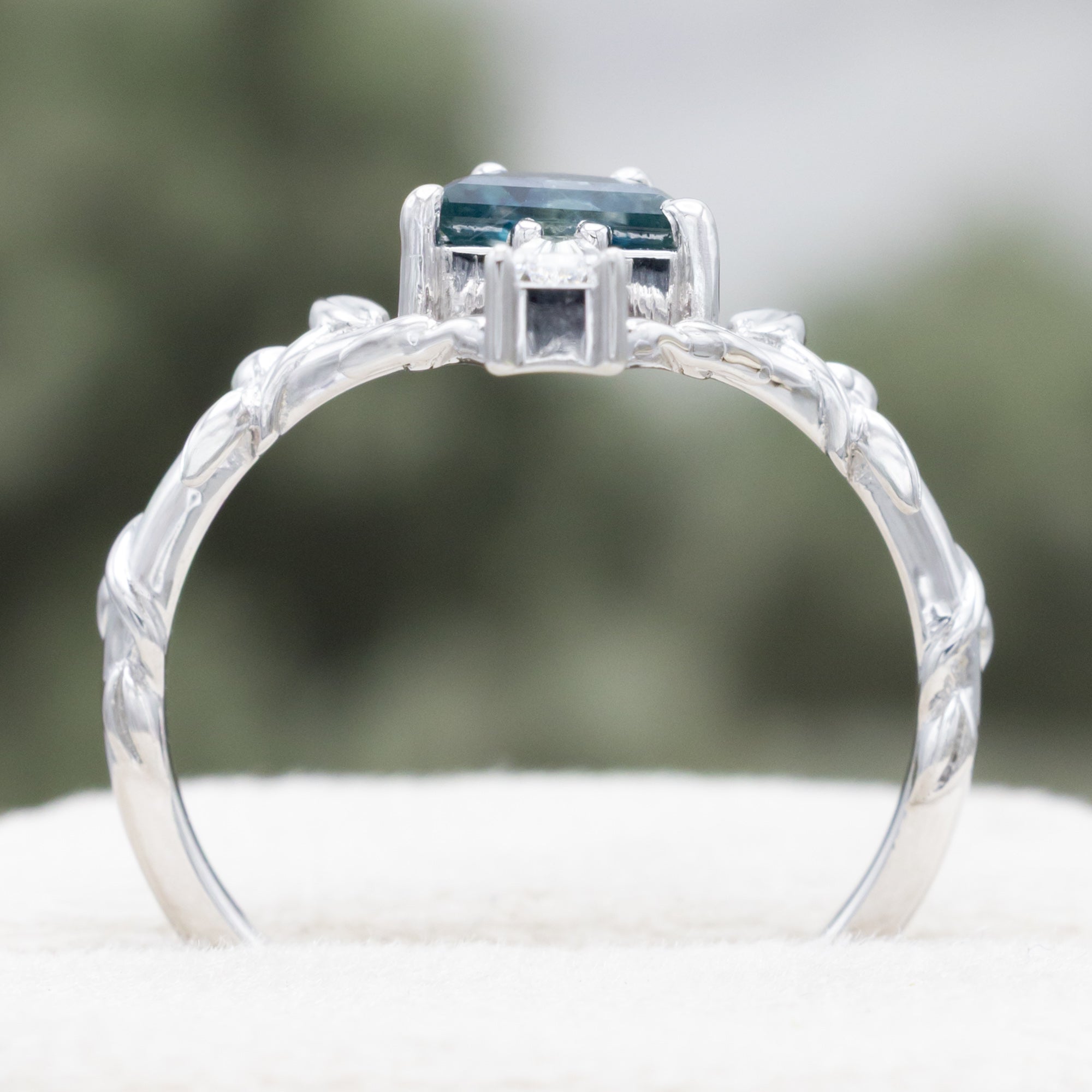 White gold mushroom ring with a blue sapphire on  a white surface