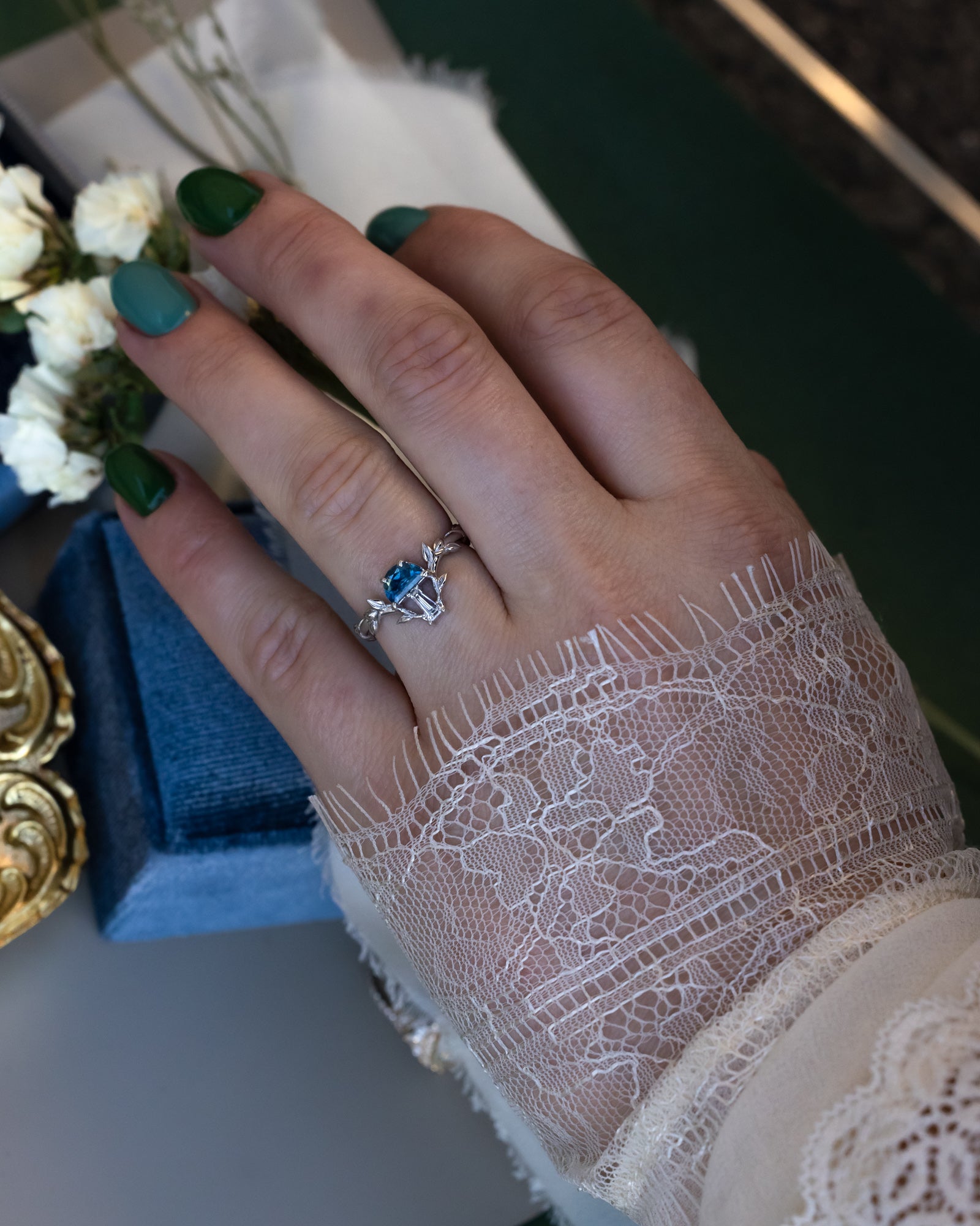White gold mushroom ring with a blue sapphire on a person's finger