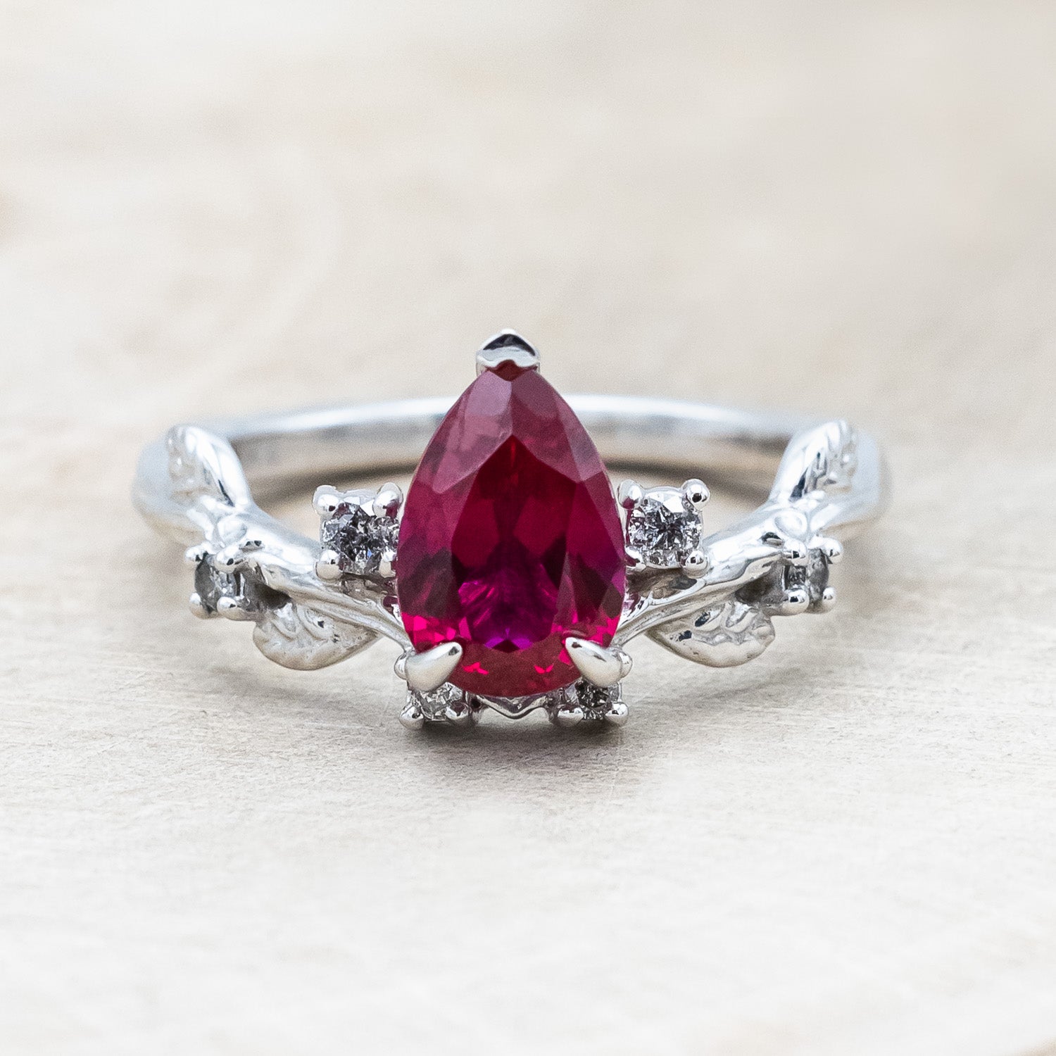 "Harlow" pear cut ruby engagement ring with salt & pepper diamond accents on a branch-inspired band