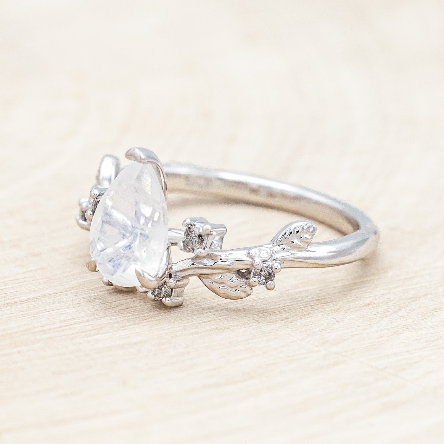 Side view of "Harlow" - moonstone women's engagement ring with salt & pepper diamond accents on a branch-inspired band