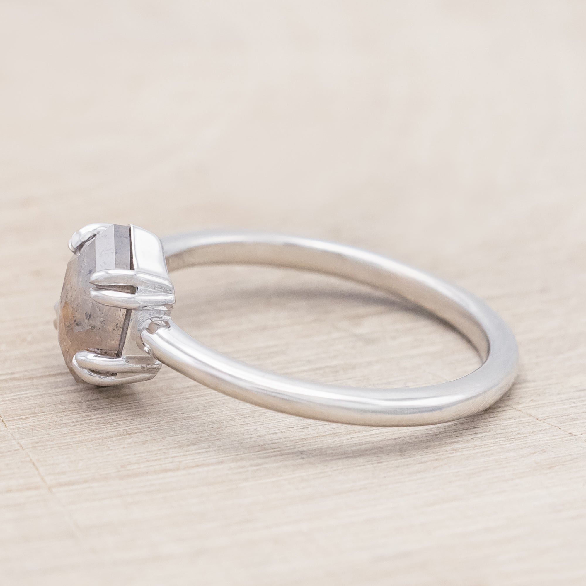 White gold ring with a hexagon salt & pepper diamond on a beige background
