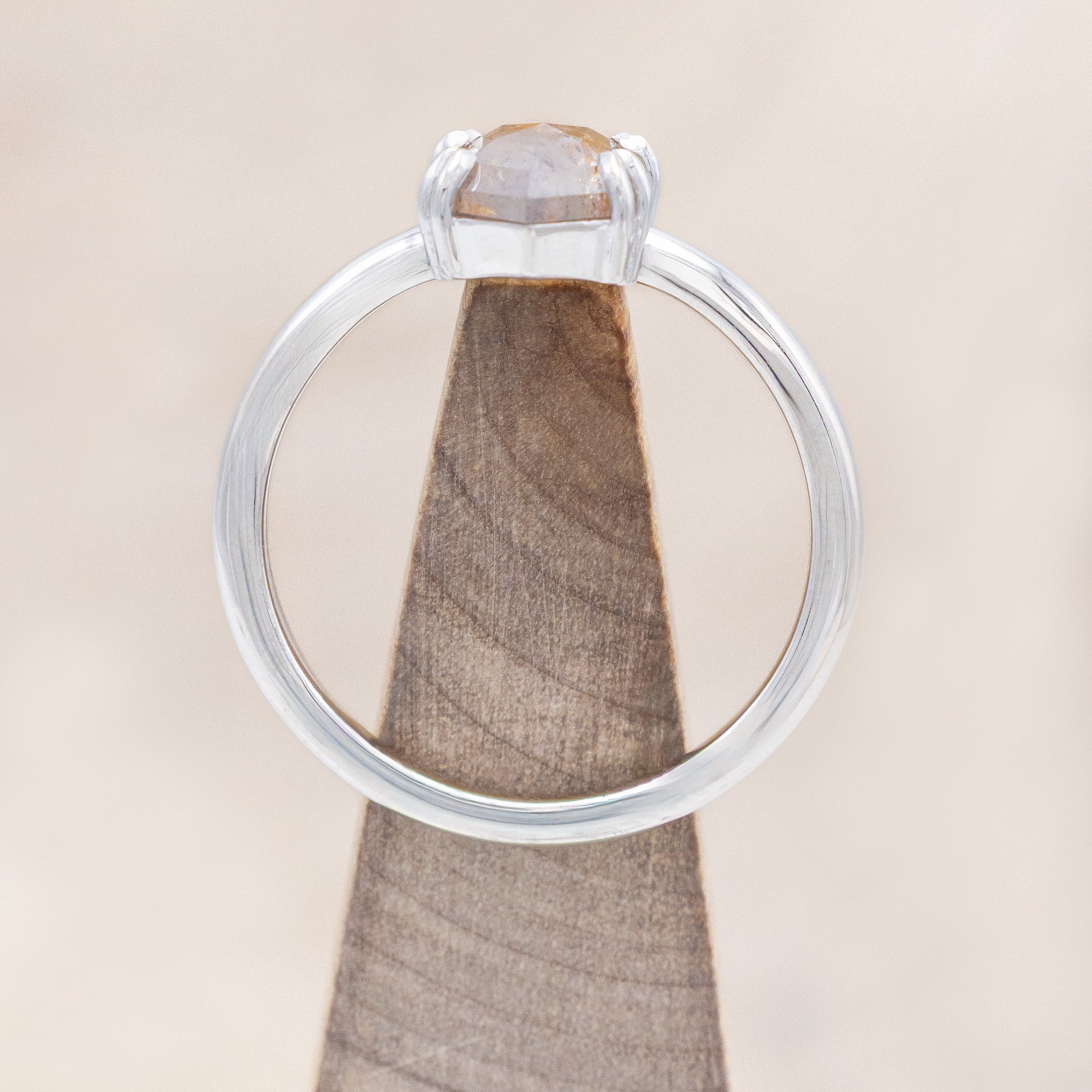 White gold ring with a hexagon salt & pepper diamond on a beige background