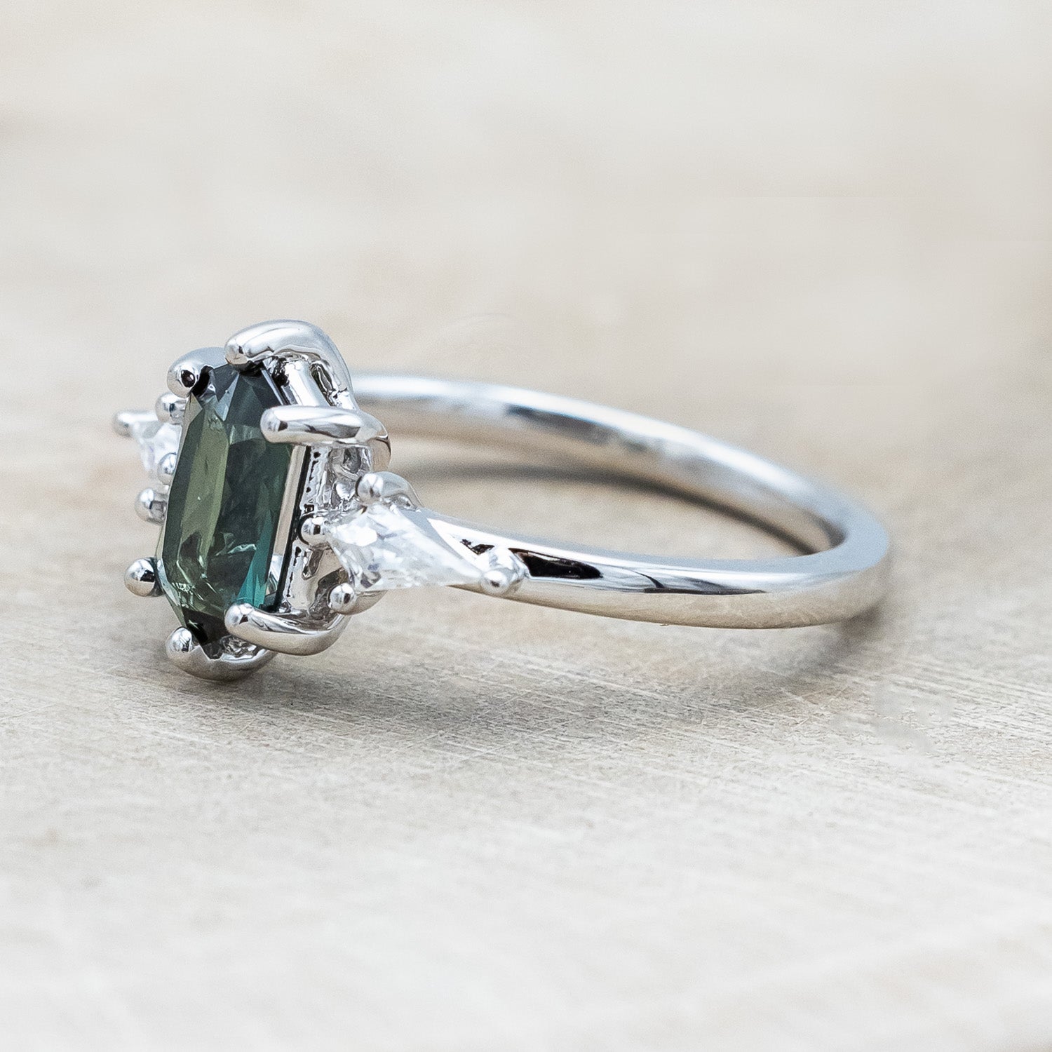 Side view of "Isla" - elongated hexagon cut Australian sapphire with moissanite accents in 14K white gold