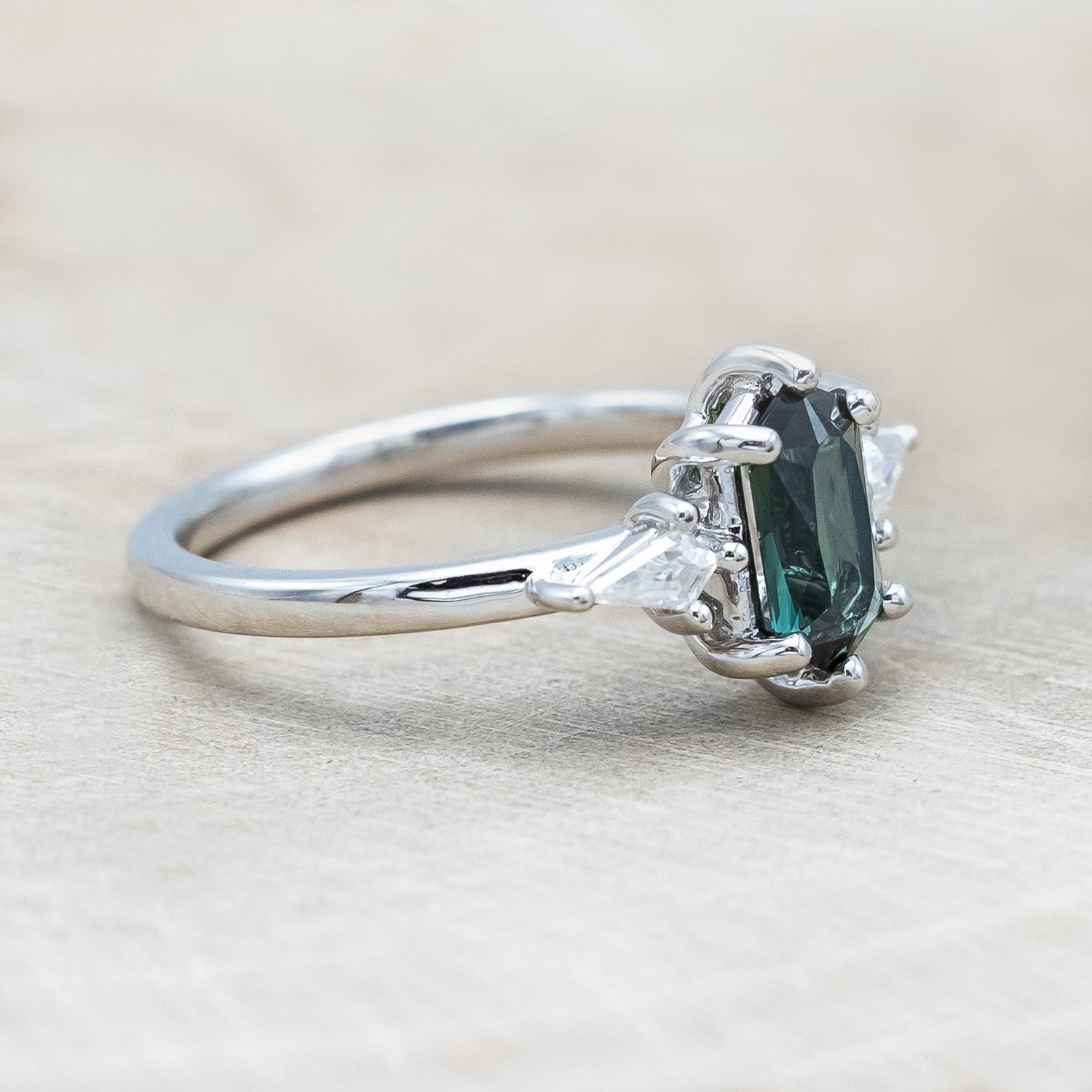 Side view of "Isla" - elongated hexagon cut Australian sapphire with moissanite accents in 14K white gold