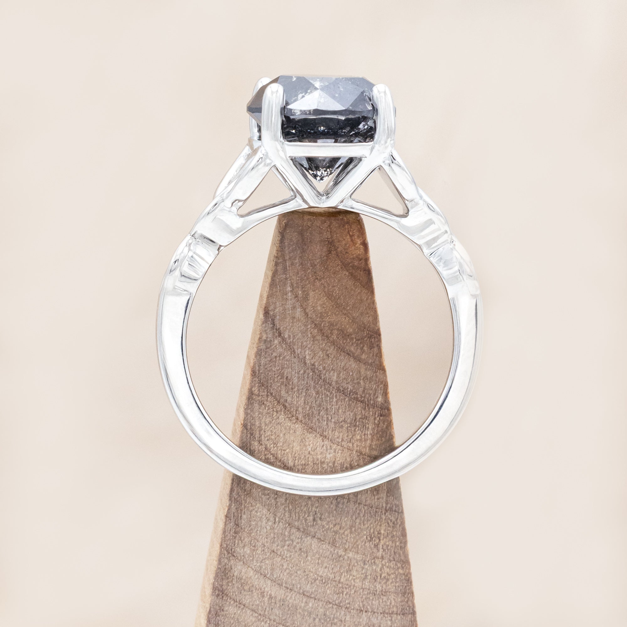 14K white gold ring with a salt & pepper diamond on a wooden surface