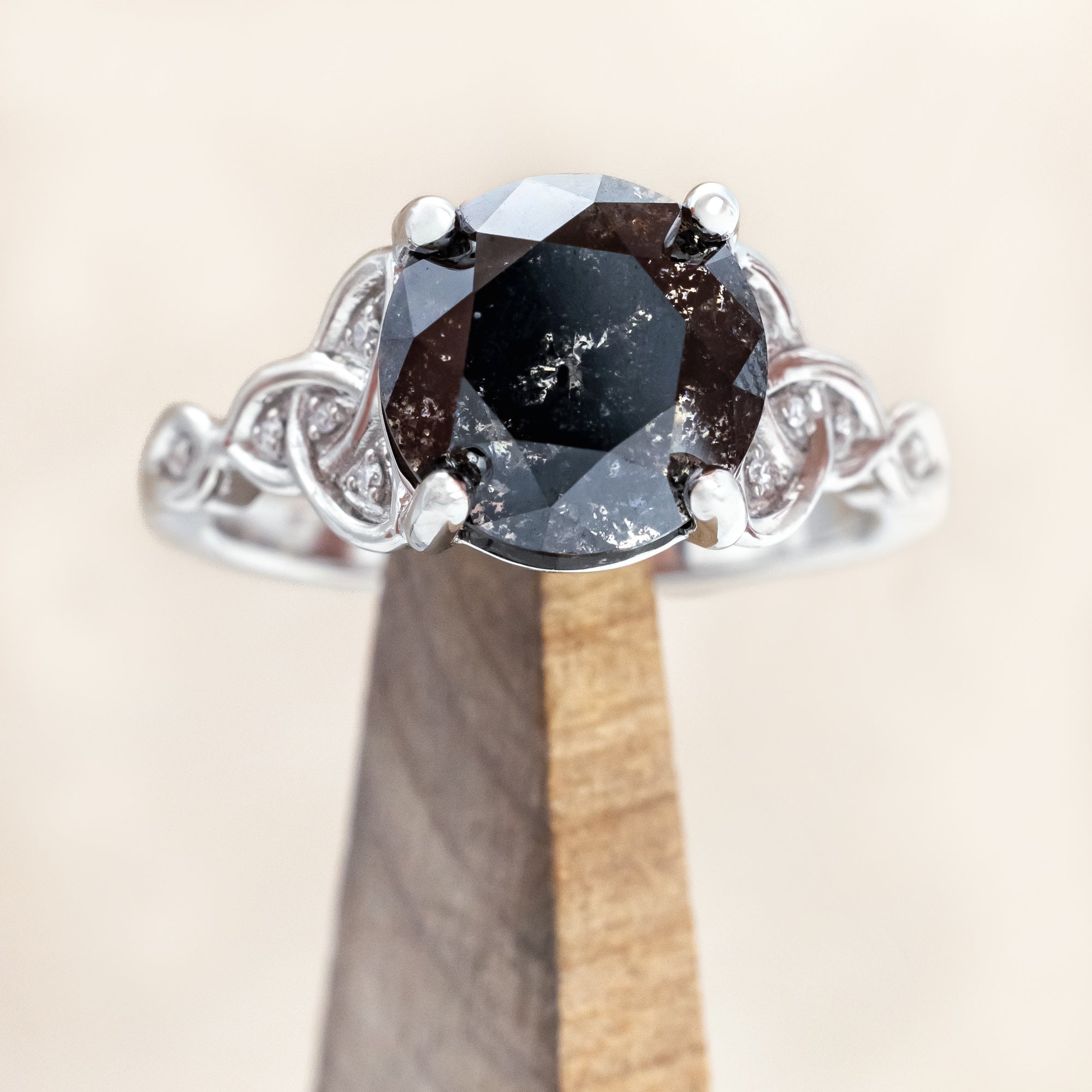 14K white gold ring with a salt & pepper diamond on a wooden surface