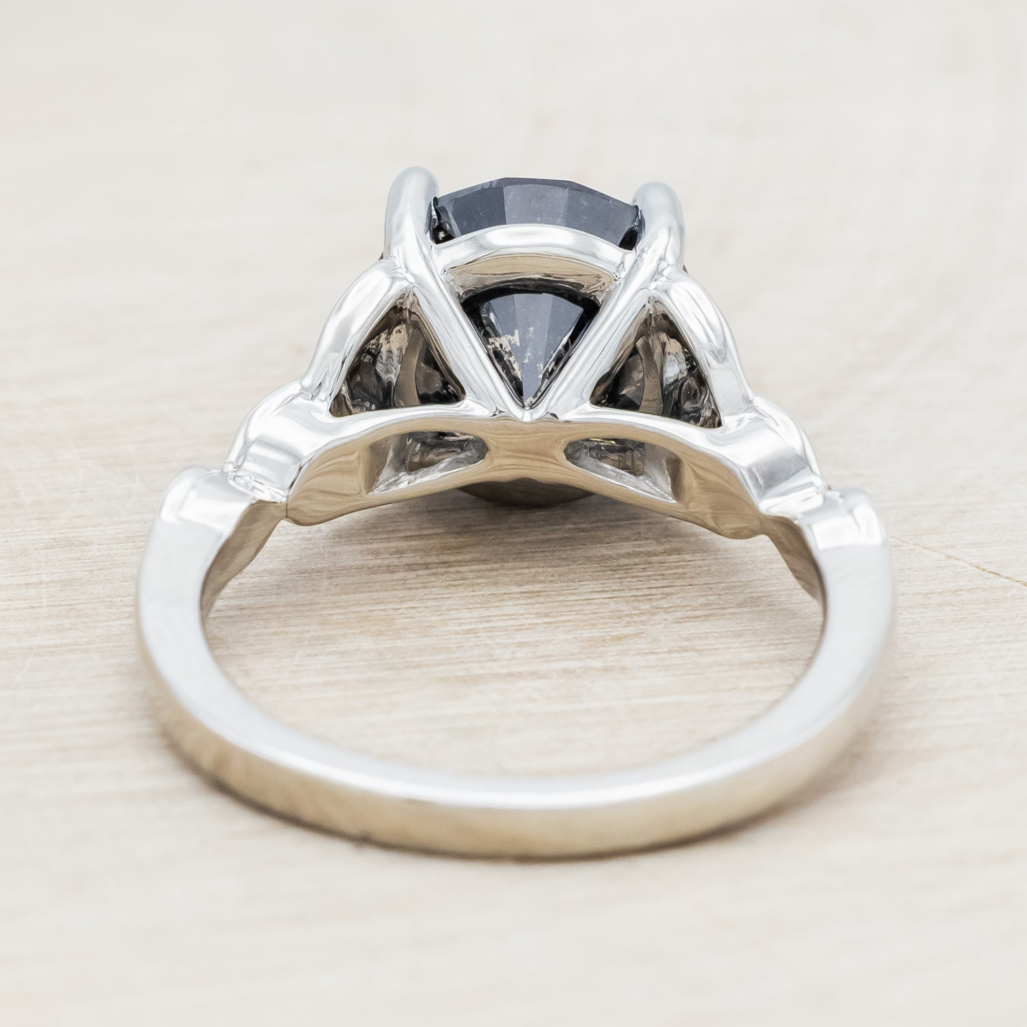 14K white gold ring with a salt & pepper diamond on a wooden surface