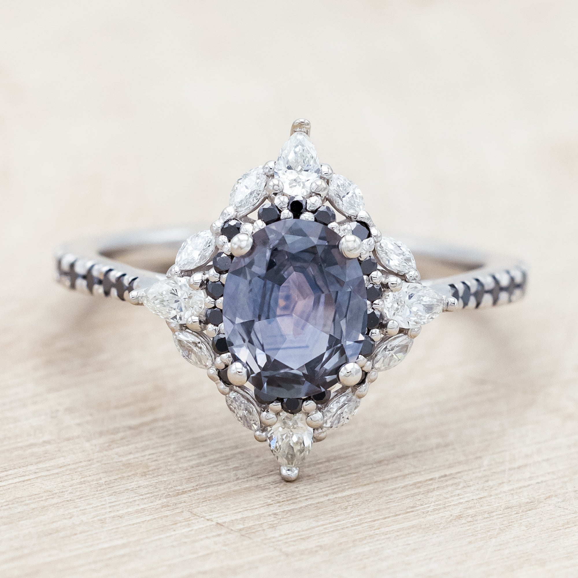 White gold ring with sapphire and diamond accents on a beige background