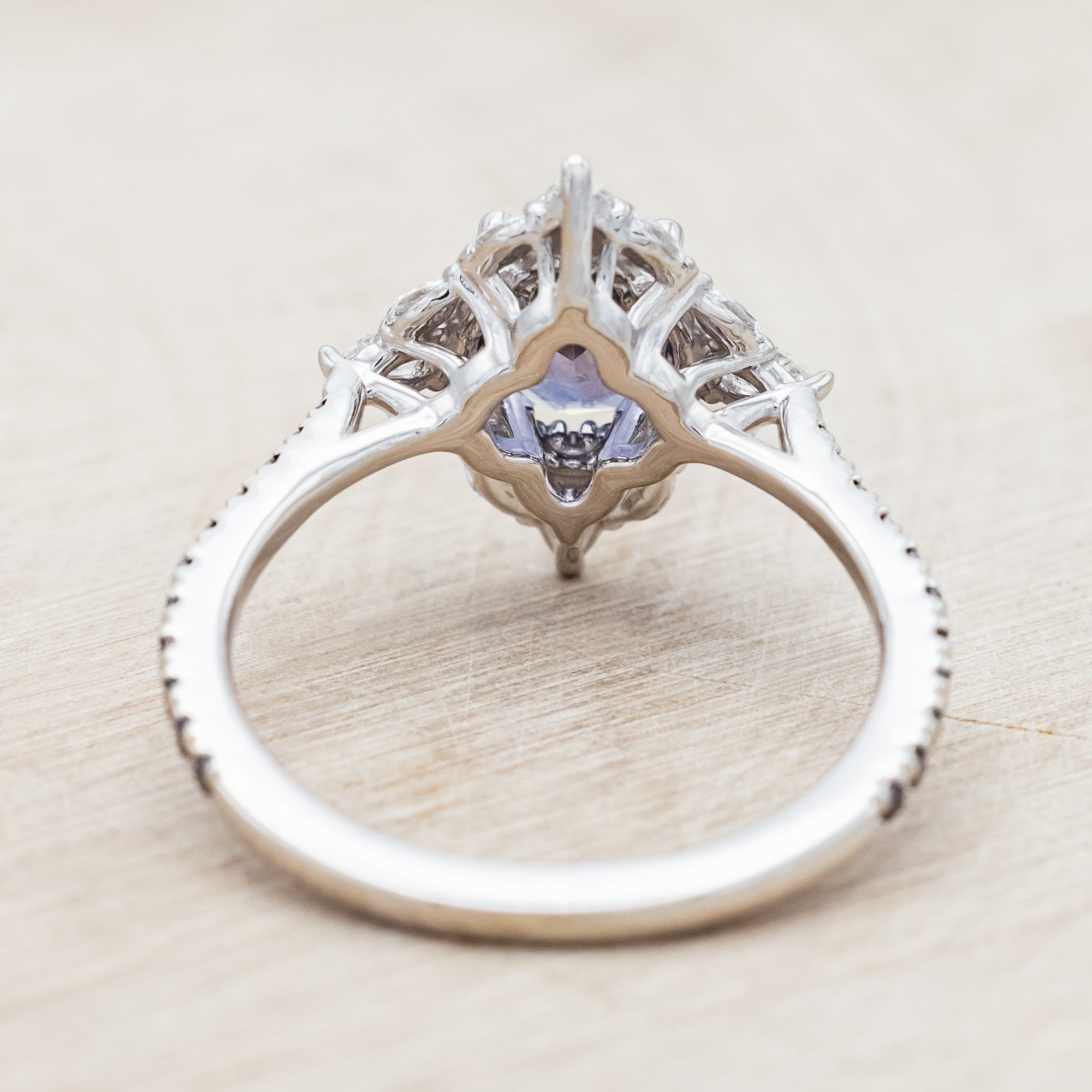 White gold ring with sapphire and diamond accents on a beige background