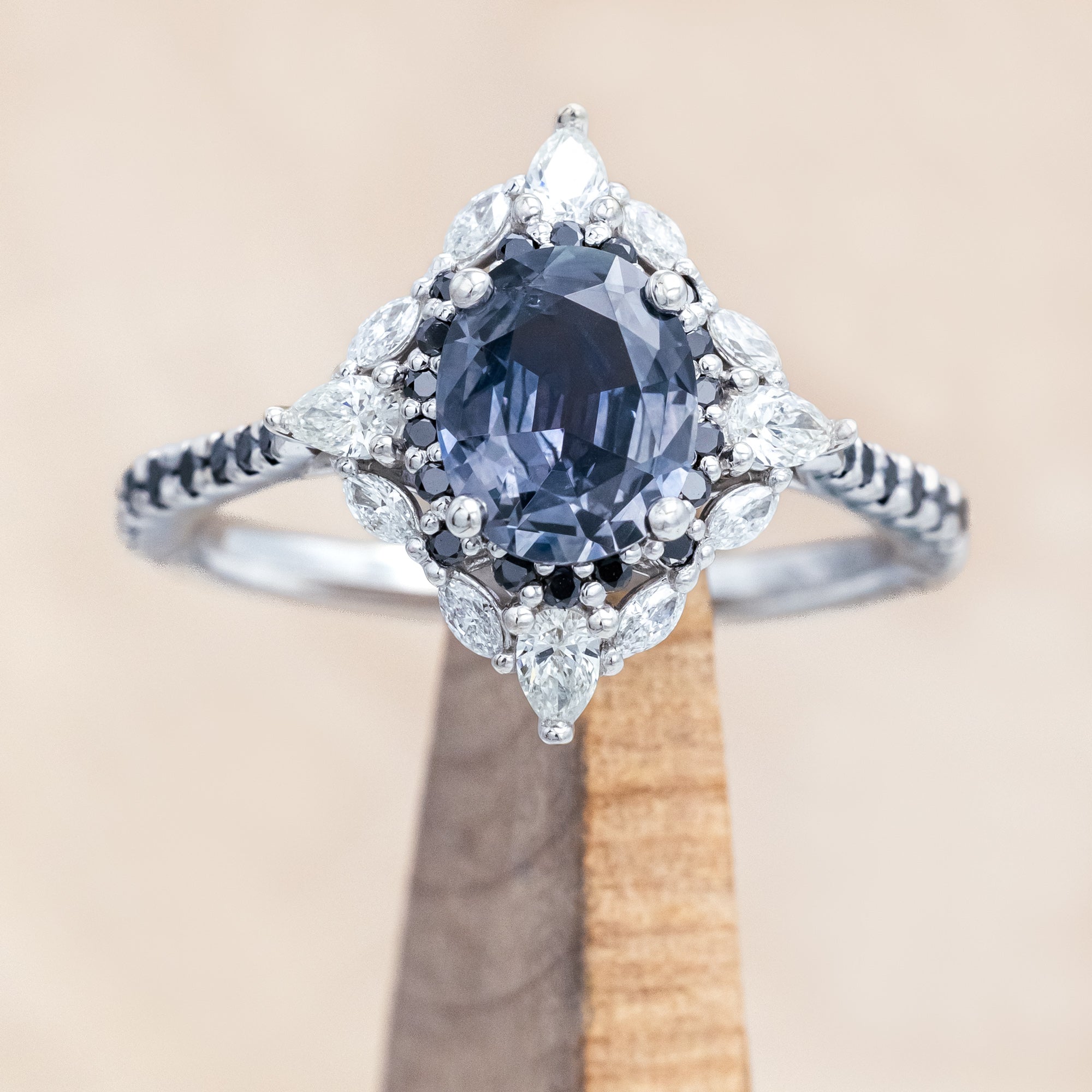 White gold ring with a blue sapphire and diamond accents on a beige background